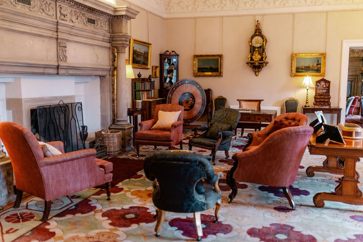 Luxurious sitting room with vintage furniture, red armchairs and decorative wall art.