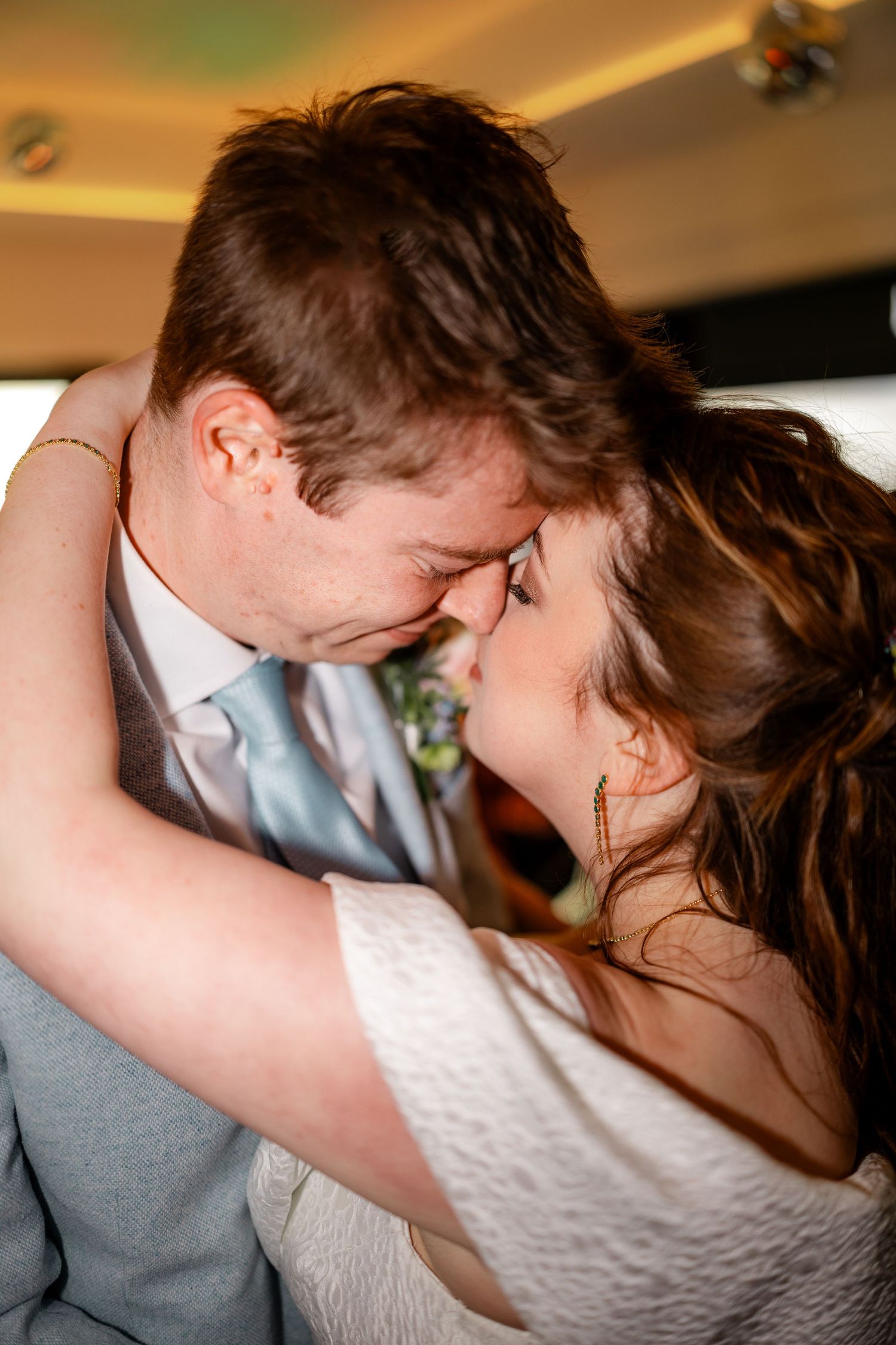 Intimate moment as bride and groom touch foreheads tenderly in a romantic close-up wedding portrait.