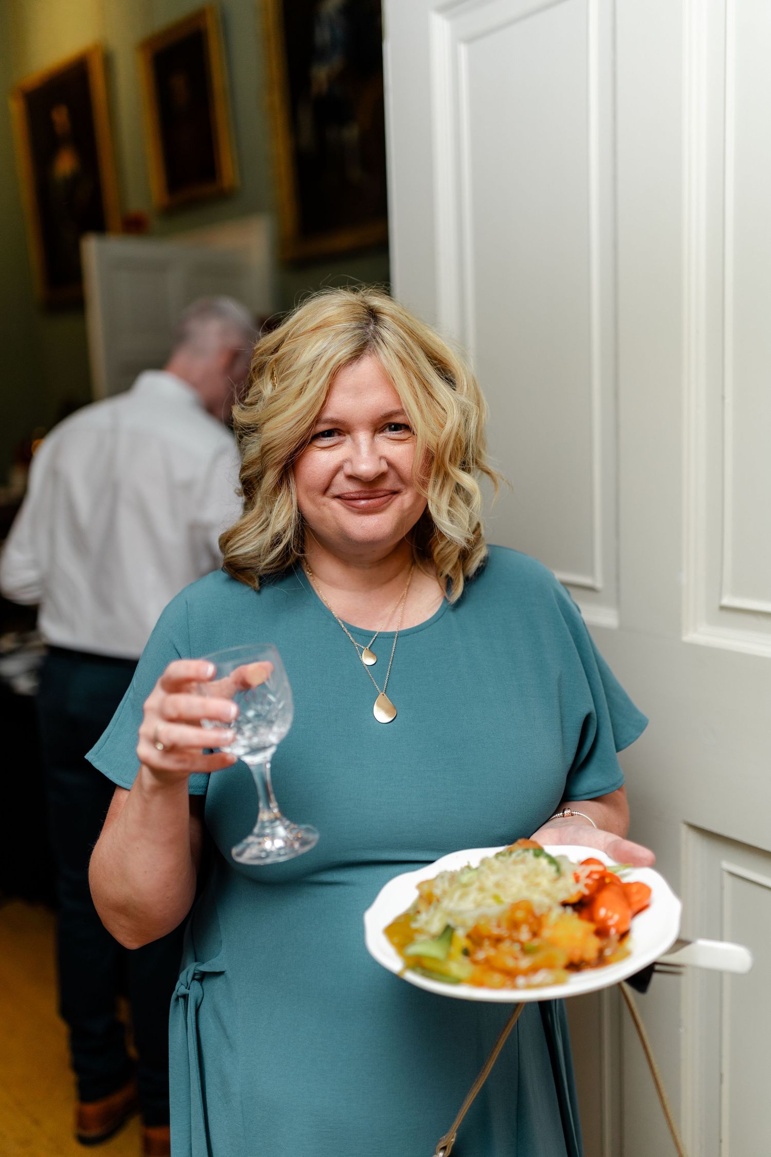 A guest enjoys food and drinks at an elegant indoor reception event.