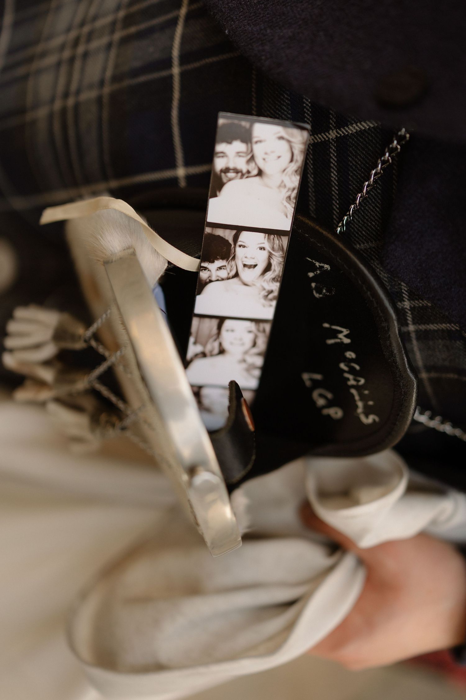 Close-up of groom's kilt with sentimental photo strip and personalized keepsake tucked into waistband.