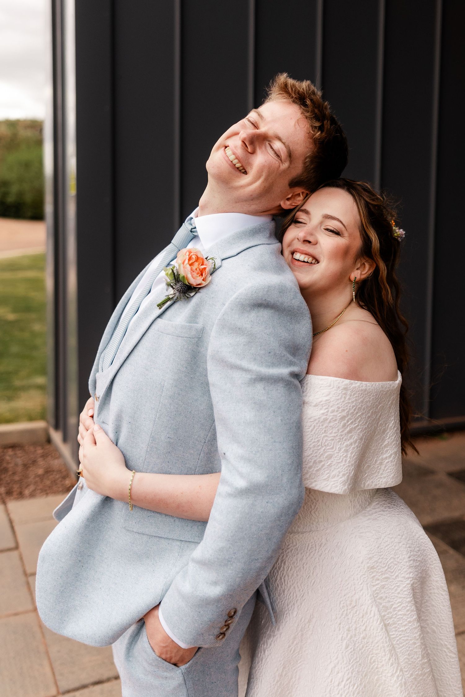 Joyful couple sharing a laugh in formal wedding attire.