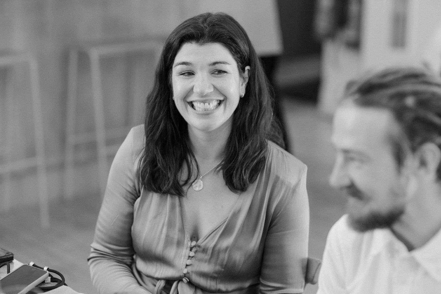 People engaged in animated conversation during a social gathering in a bright indoor space.