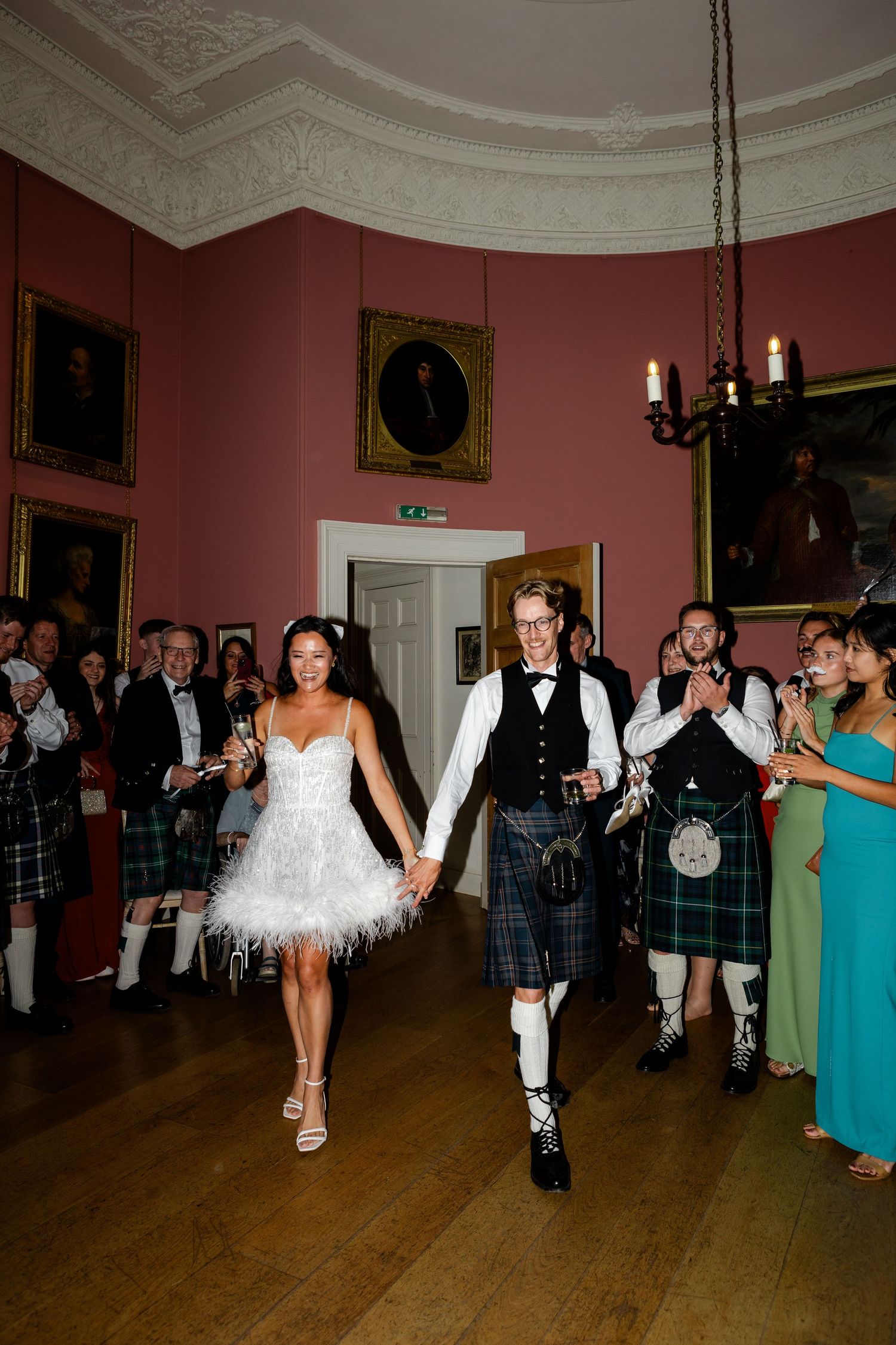 Couple makes grand entrance at Scottish wedding reception in traditional and modern formal attire.