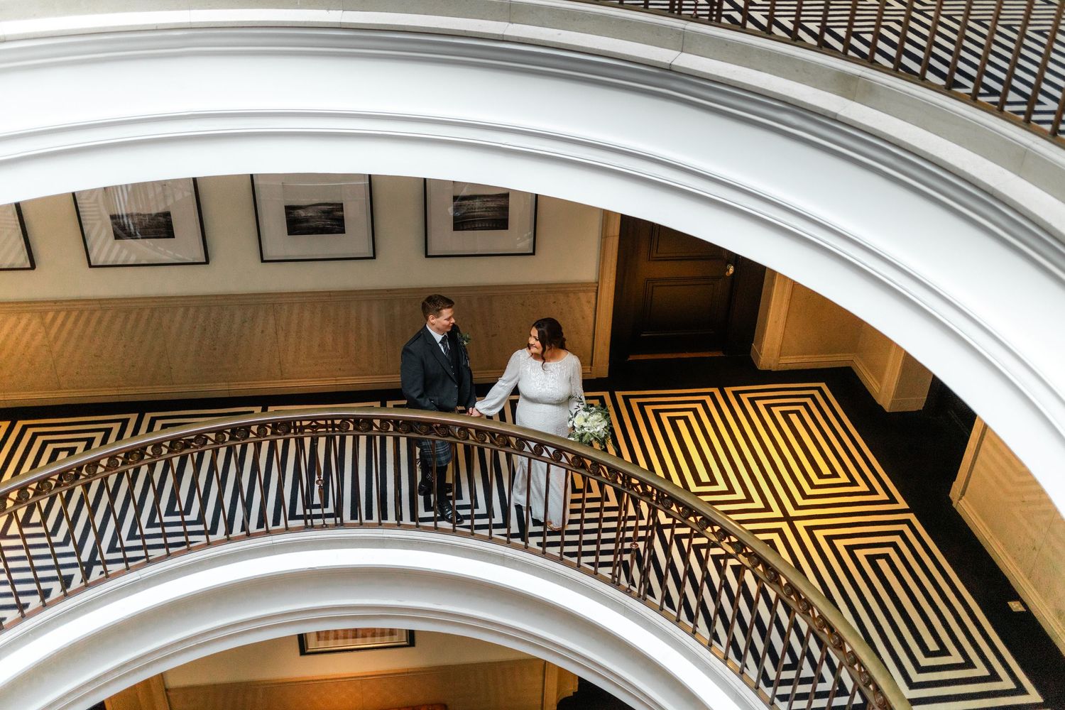 Overhead view of a couple walking across a geometric patterned floor in an elegant venue.