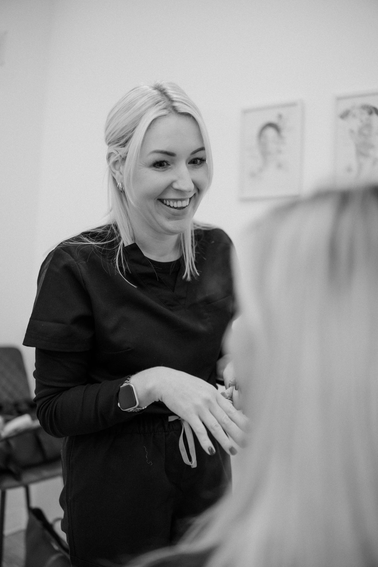 Black and white portrait of medical professional laughing in clinic setting.