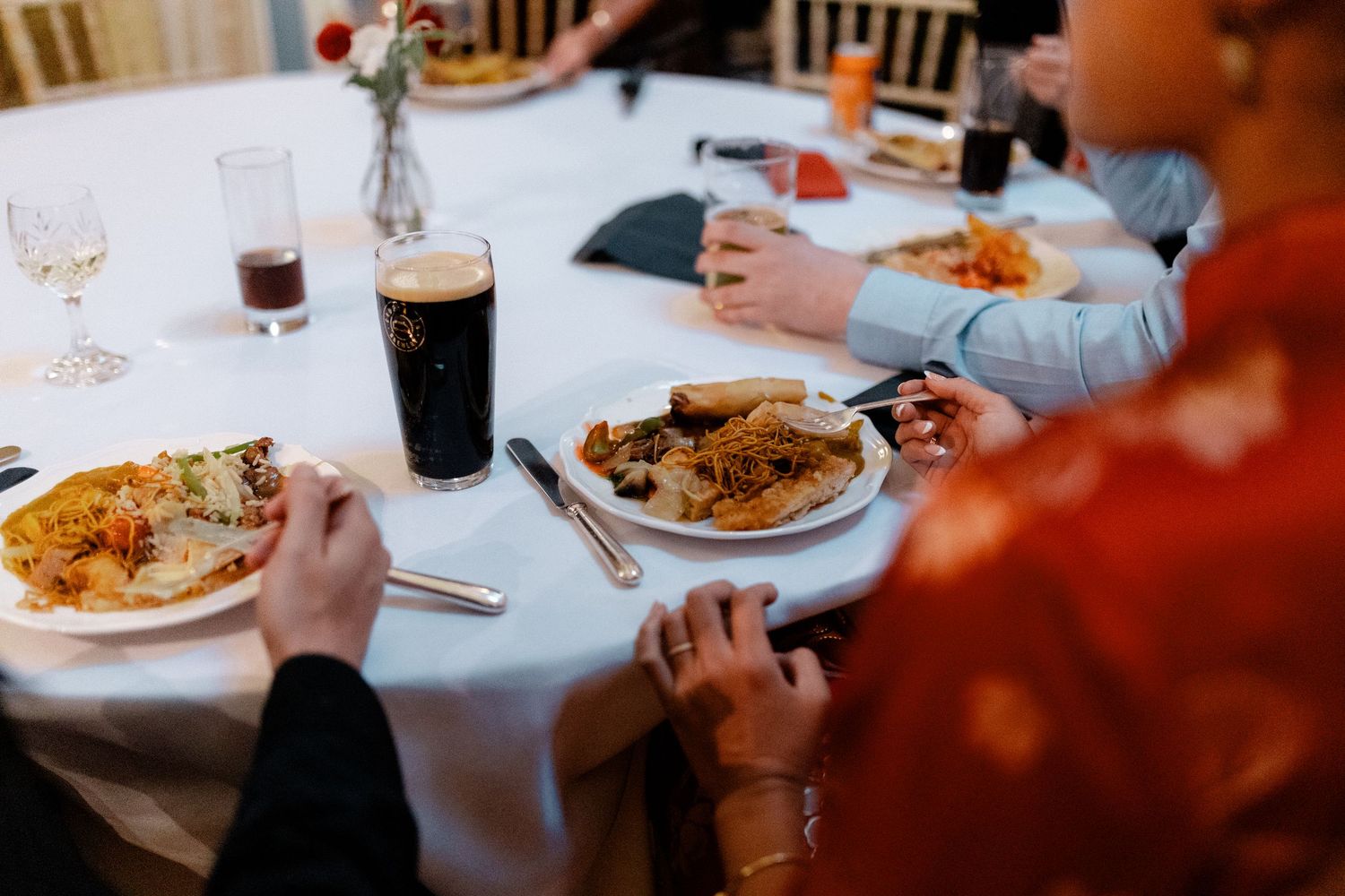 Dining table set with white tablecloths and plates during a meal service.
