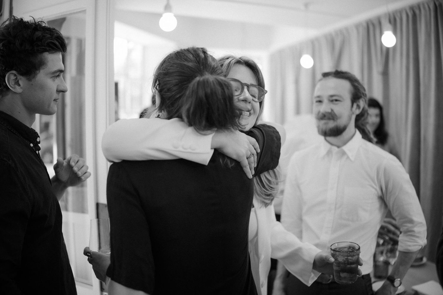 Black and white photo of people interacting at a social gathering.