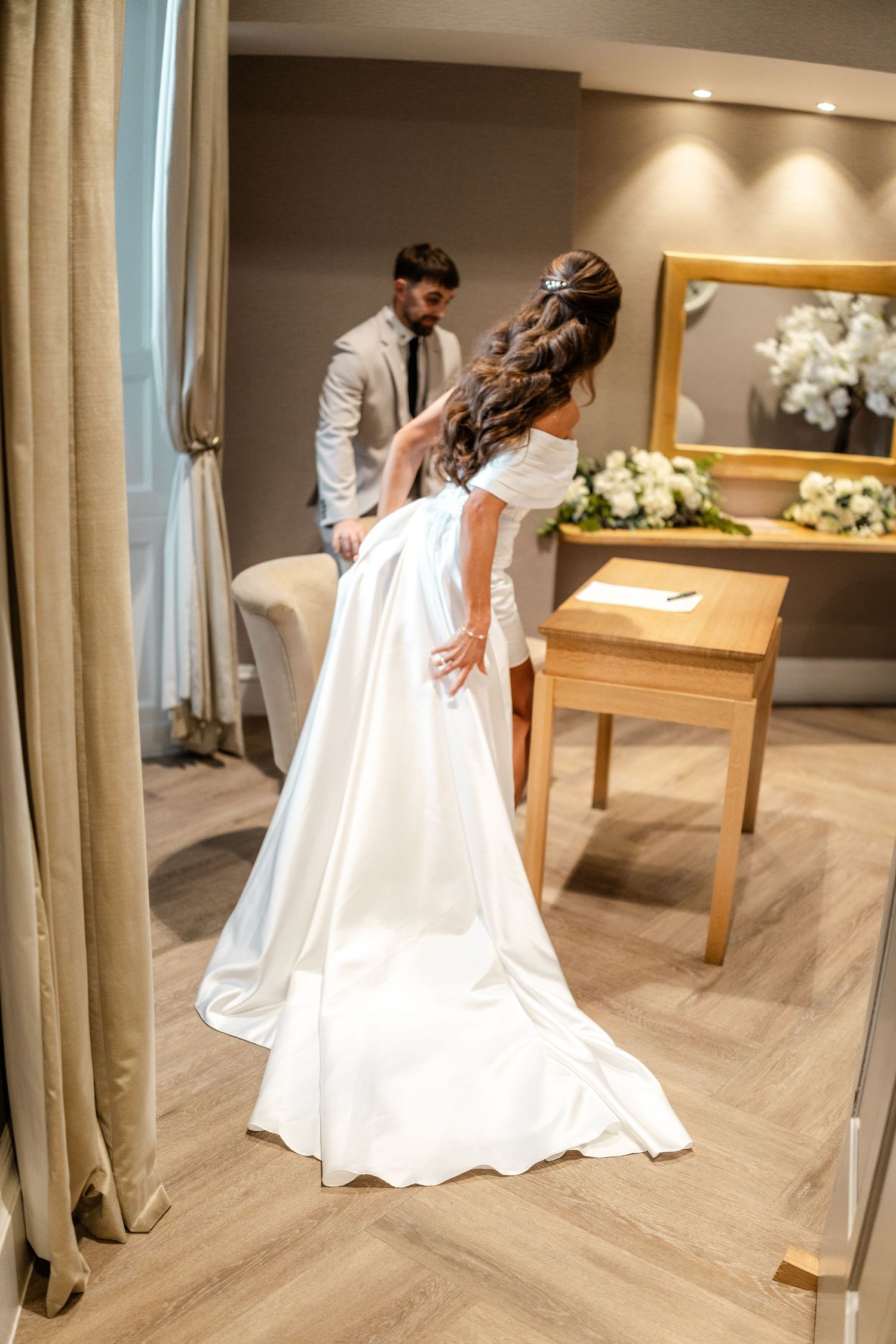 Newlyweds share intimate moments in an elegantly furnished room.