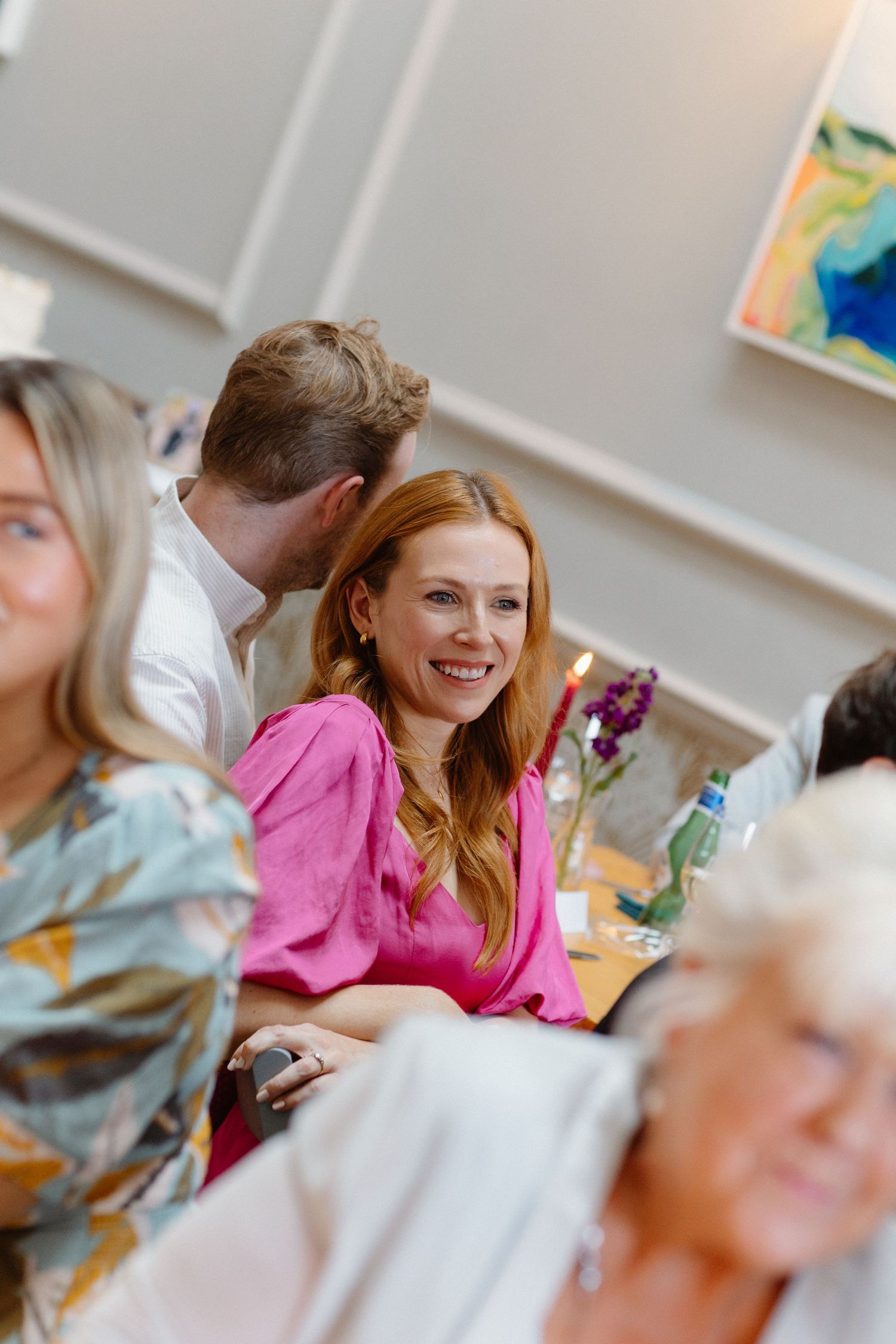 Wedding reception guests enjoying a celebration in a bright indoor venue.