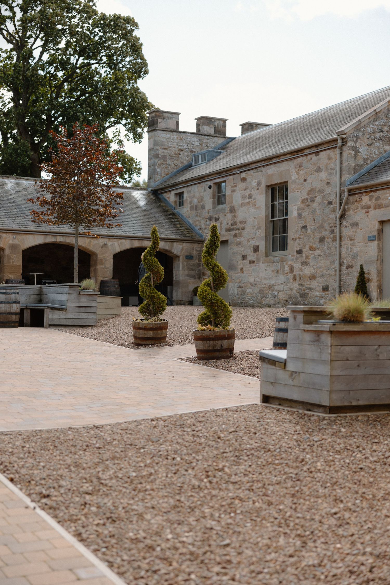 Stone courtyard with decorative planters and paved walkways at a historic estate property shows architectural details.