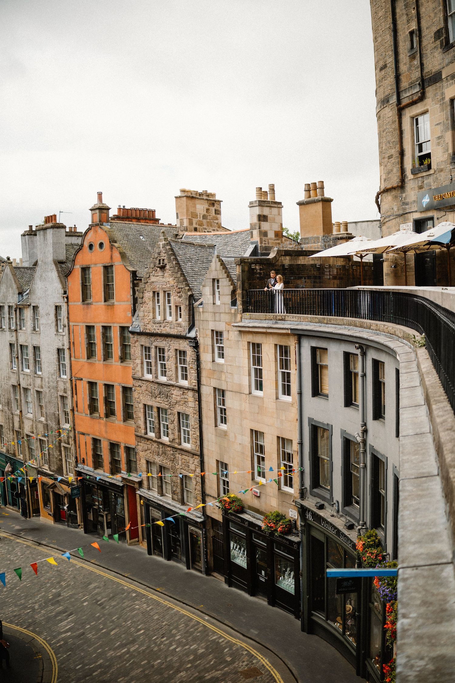 Scenic view of historic curved Victoria Street in Edinburgh with colorful buildings and cobblestones.