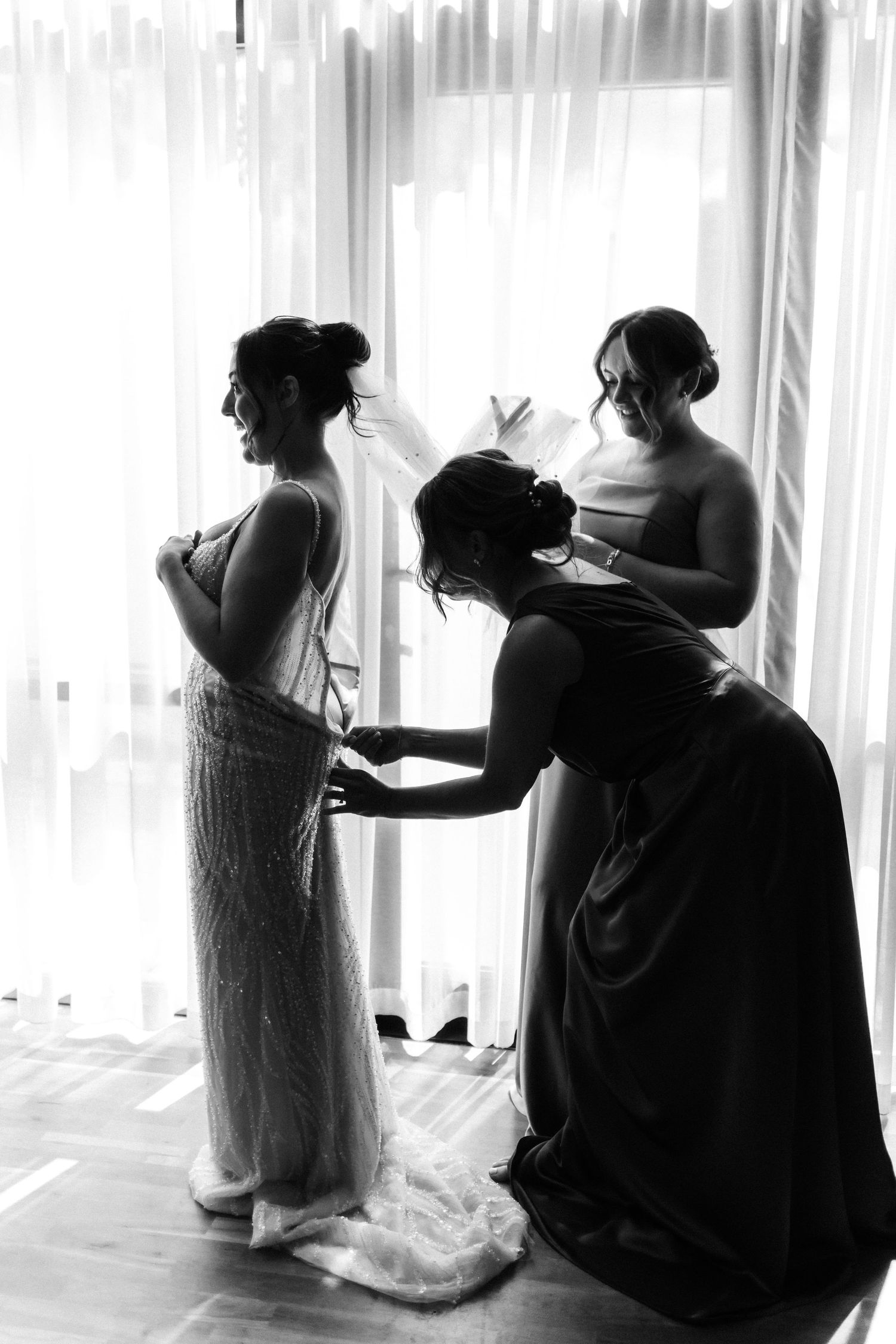 Bride black and white photo, fitting dress, friends helping her Glass House Edinburgh, Scotland,