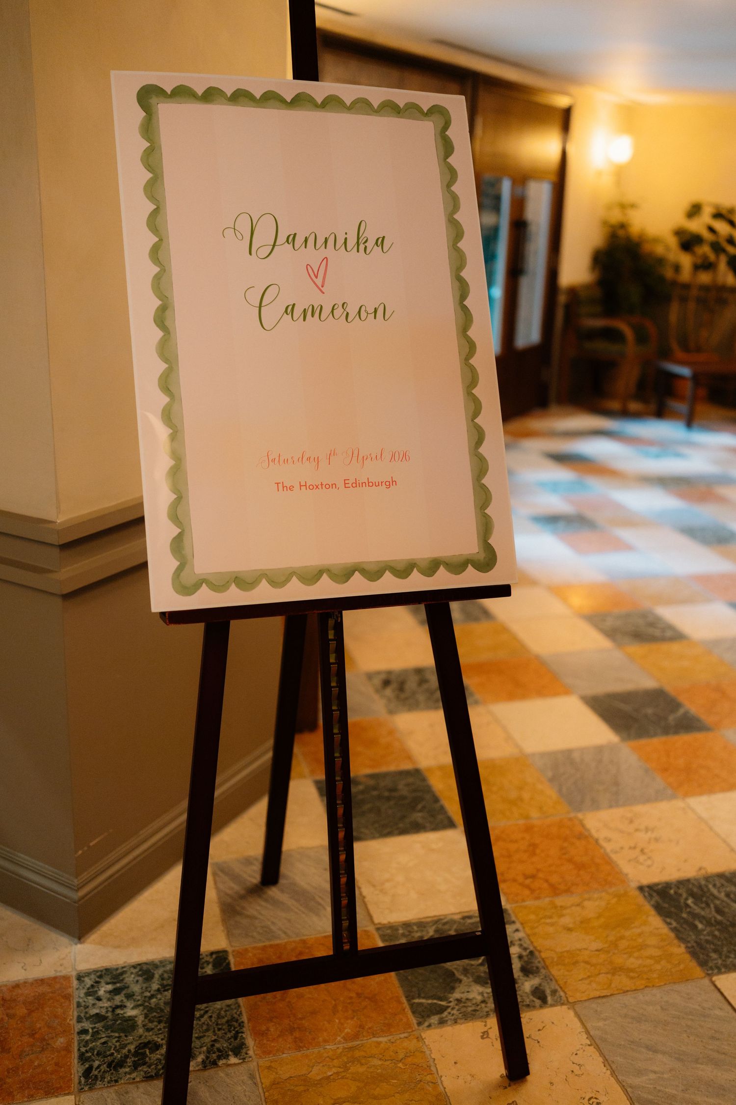 Wedding welcome sign for Dannika and Cameron on an easel at The Hoxton Edinburgh, featuring green scalloped border.