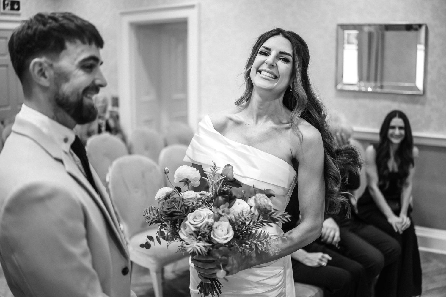 Black and white candid moments from an indoor wedding celebration.