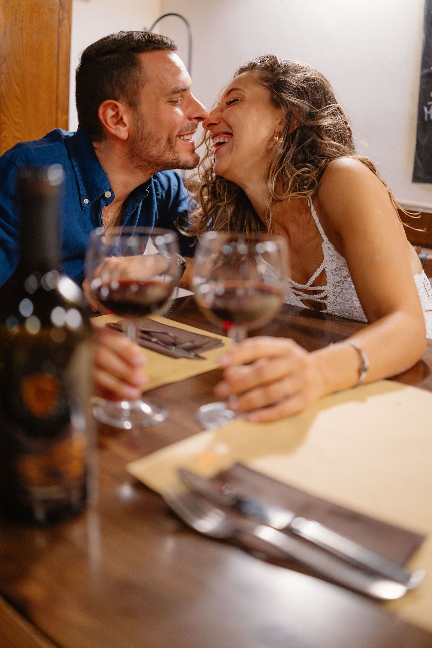 Intimate dining scene with wine glasses and romantic moments at a restaurant table.