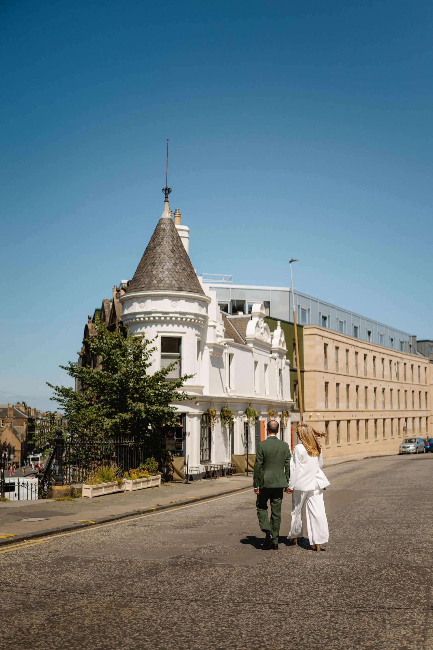 White buildings with colonial architecture line a cobblestone plaza under bright blue sky.