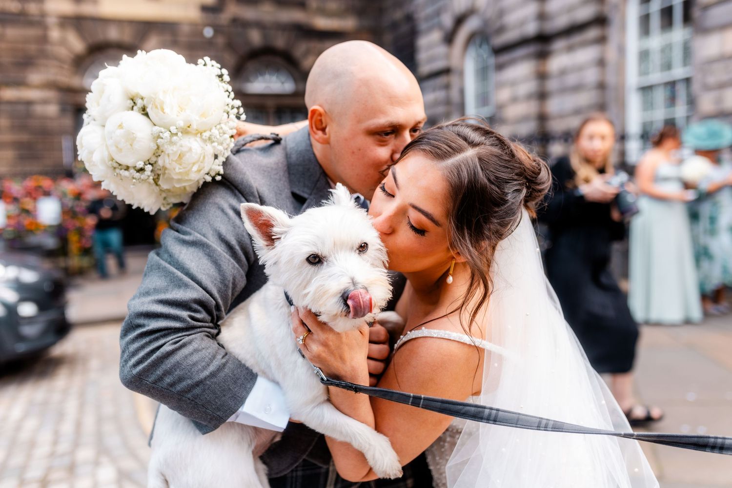 Bride kissing dog and groom kissing bride,  City Chambers wedding in Edinburgh, Scotland,