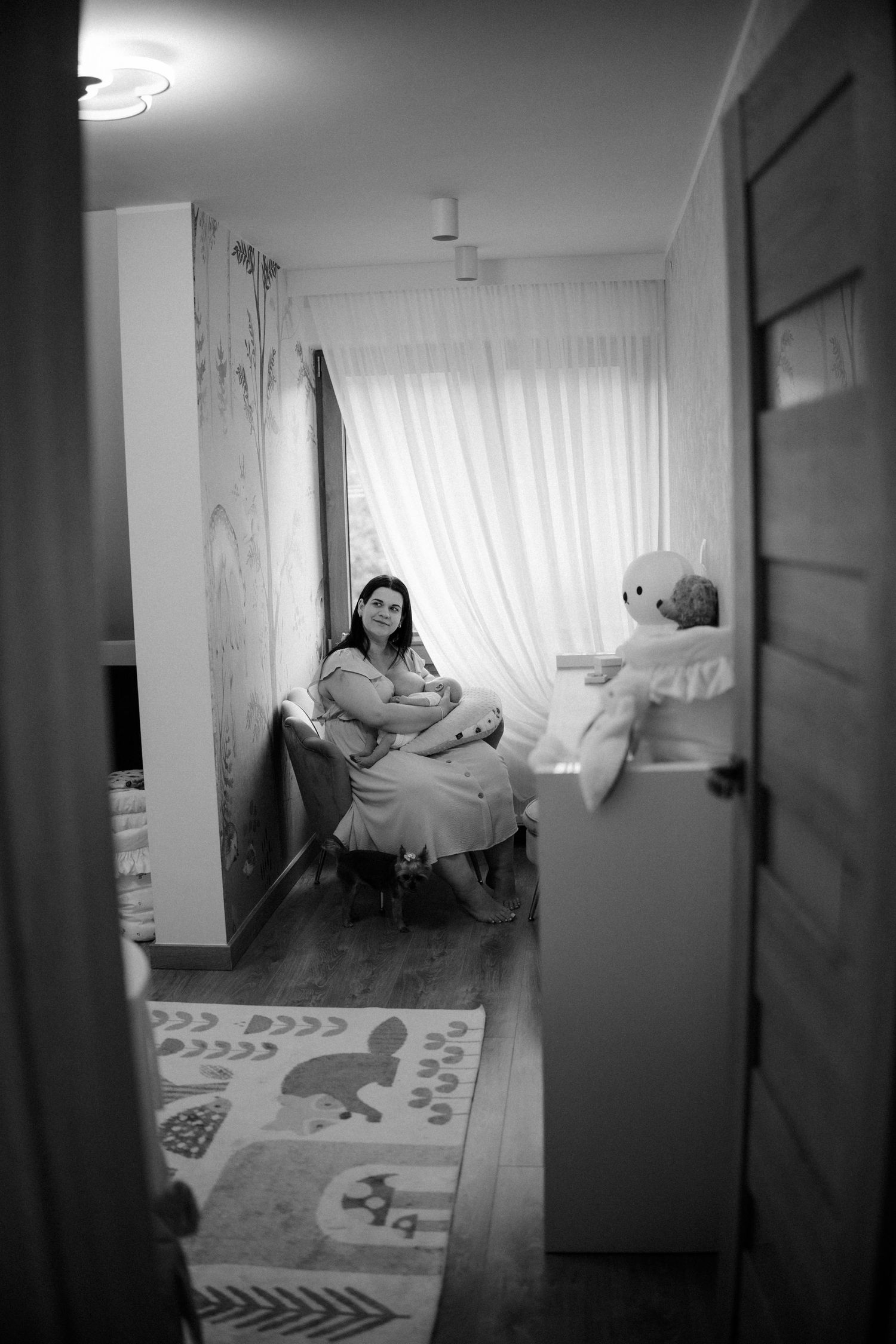 Black and white interior photograph of nursery room with window light.