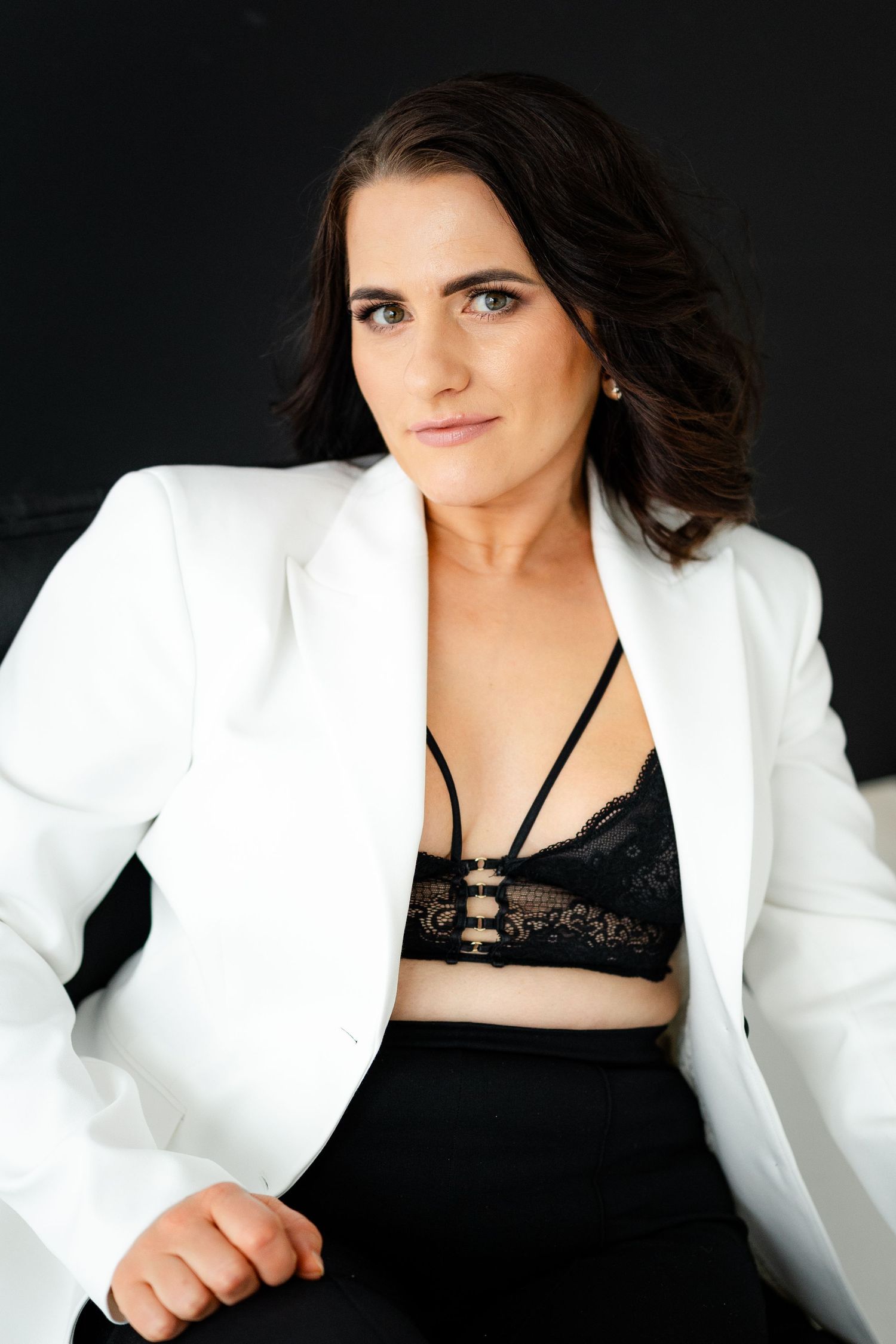 Fashion photography series featuring white blazer and black lace styling against dark background.