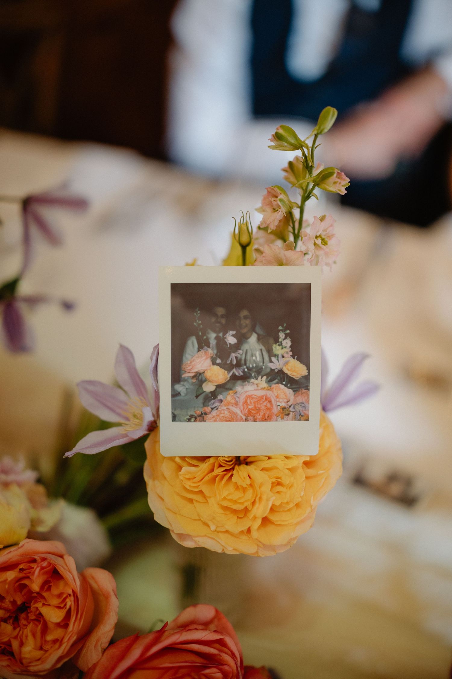 Orange roses with name cards arranged as elegant wedding table centerpieces.