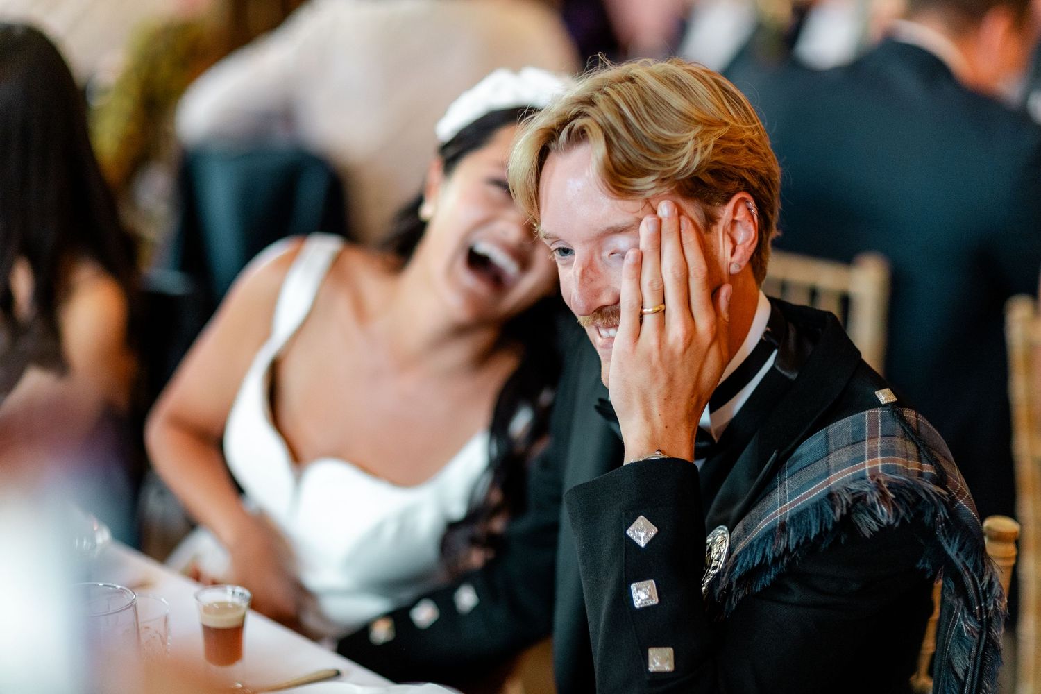 Candid moments of guests laughing and enjoying themselves at a formal dinner event.