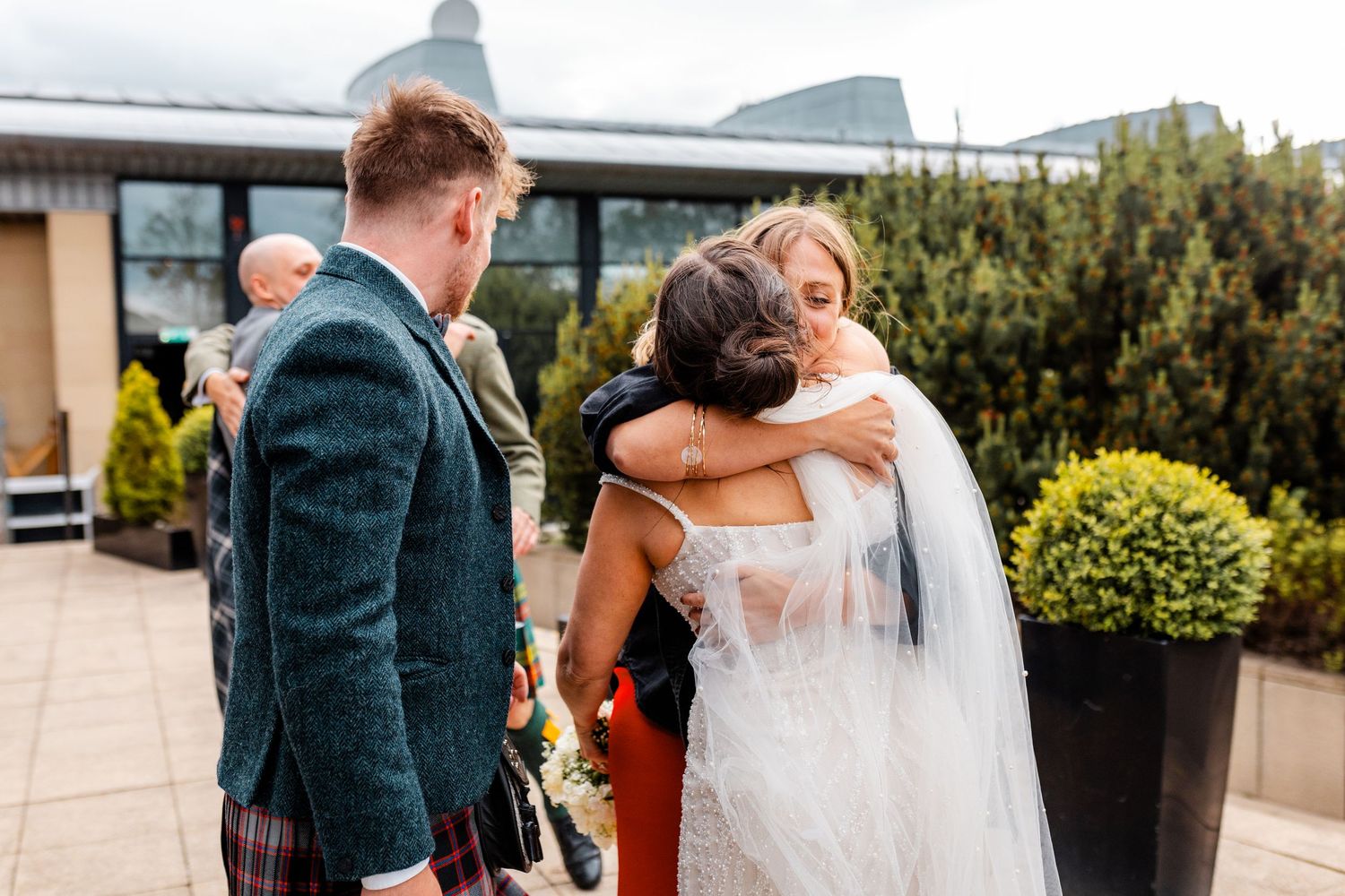 Hugging sister with the bride outside of the Glass House, Edinburgh, Scotland.