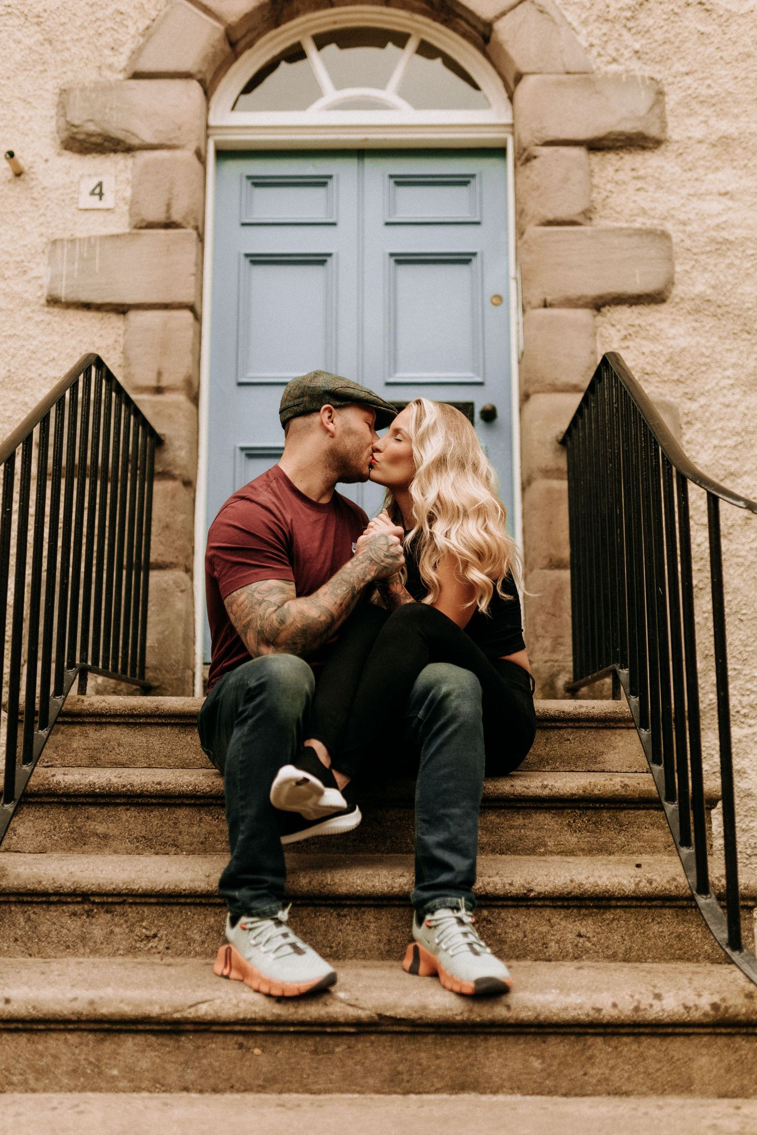 Couple sharing intimate moments on stone steps in front of a classic Georgian doorway.