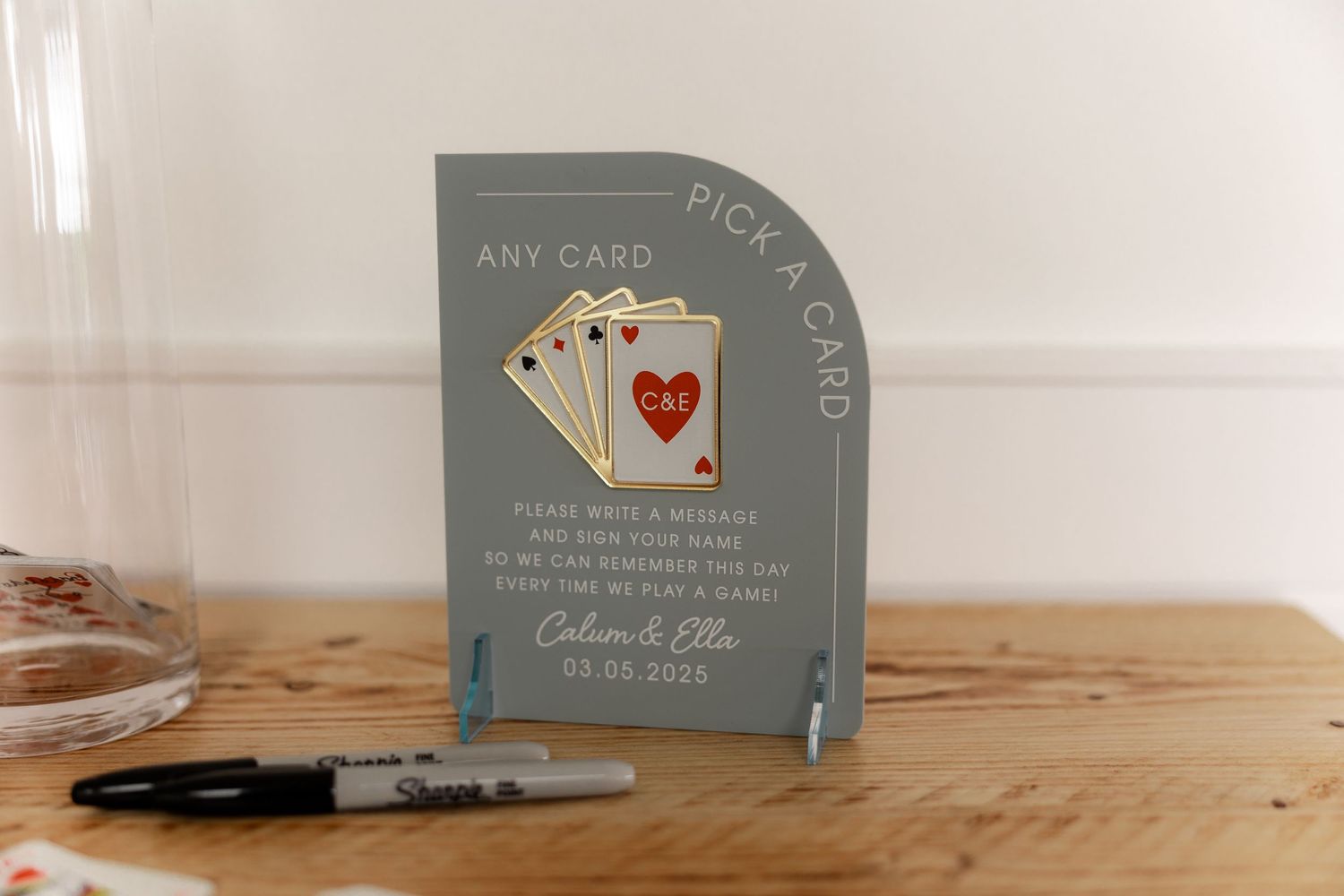 Gray acrylic pick a card wedding sign with playing cards design, personalized with couple names Callum and Ellie.