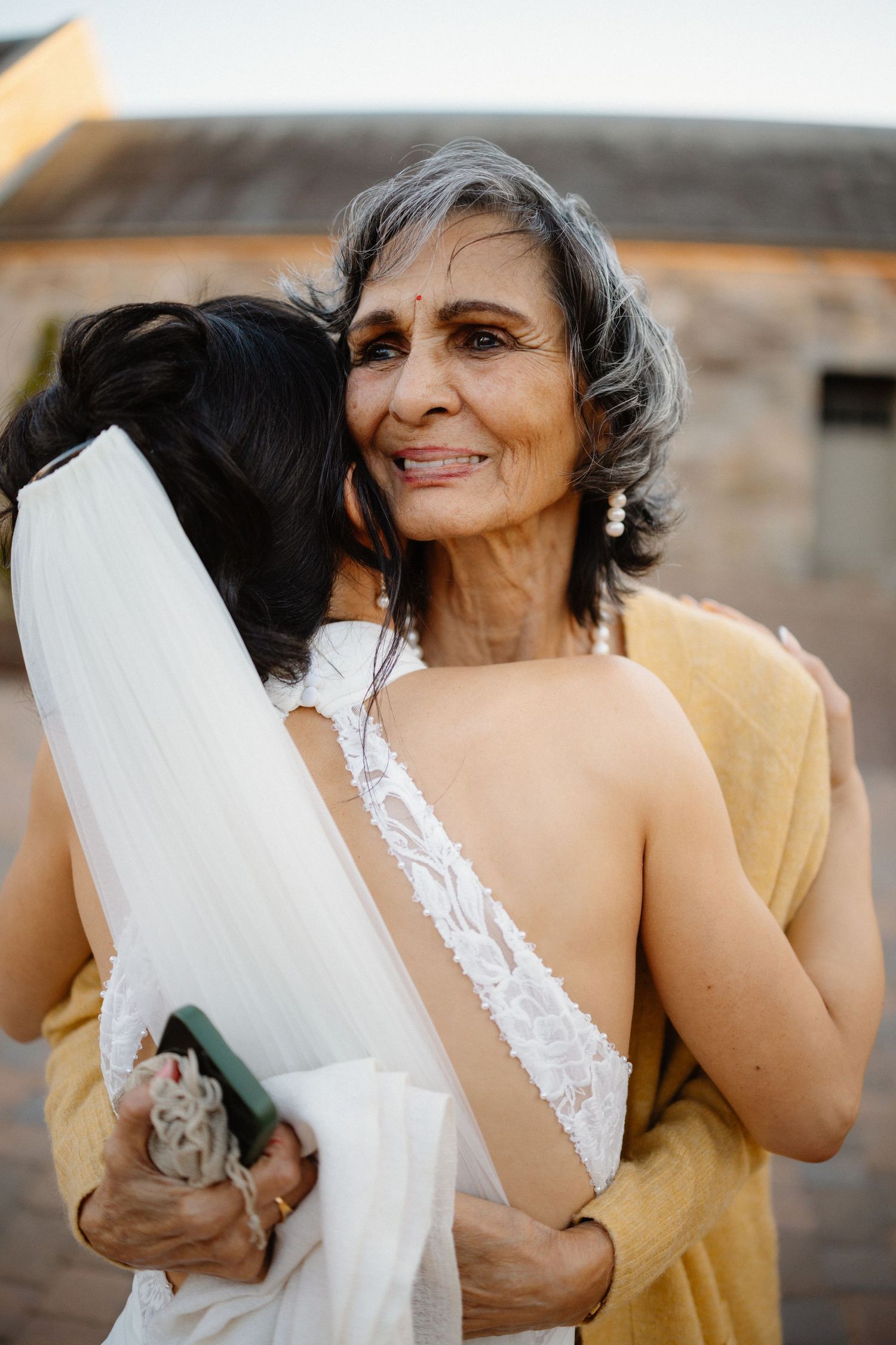 Intimate wedding moments captured in warm sunlight against stone architecture.