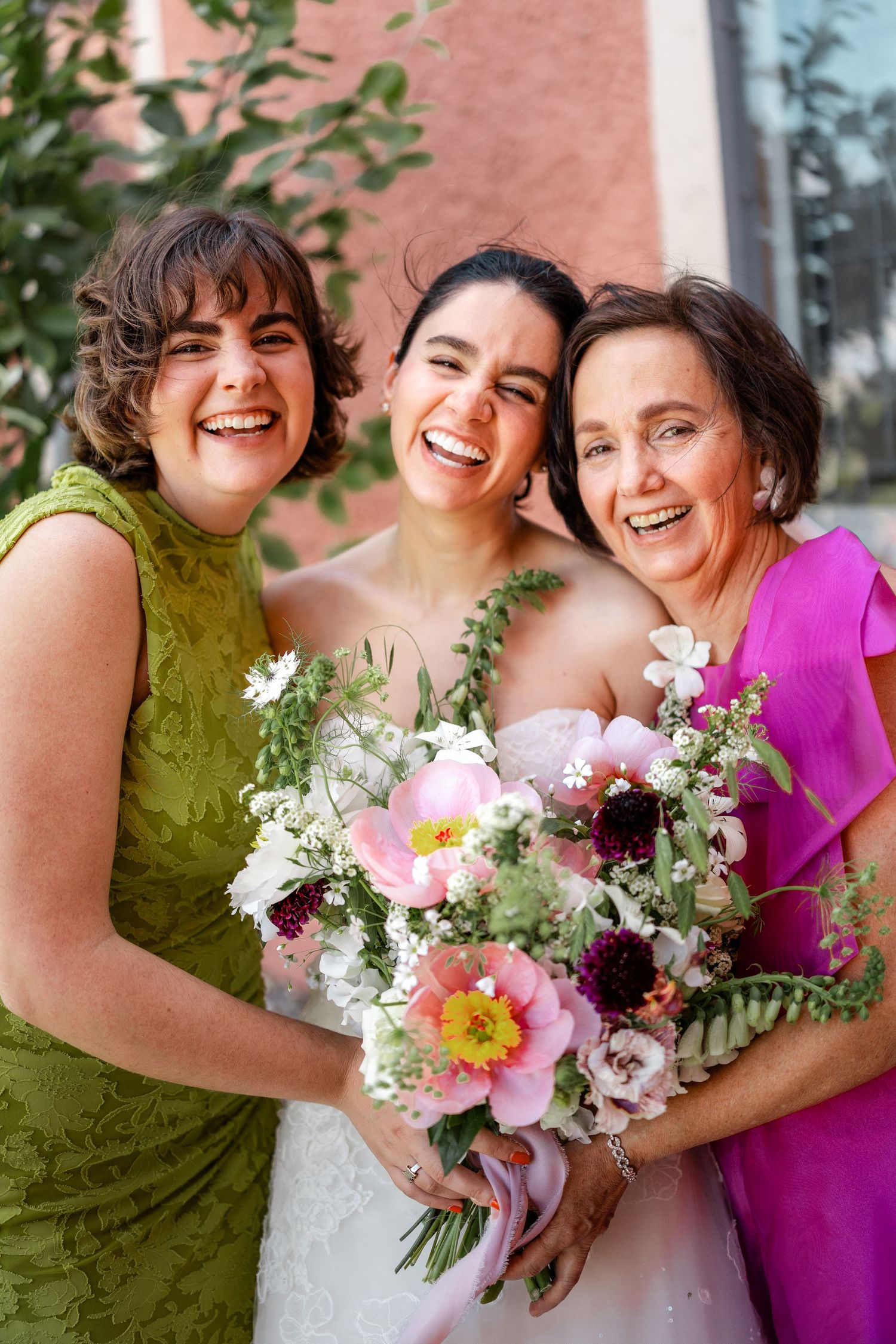 Wedding party holding colorful bouquets of pink and white flowers.