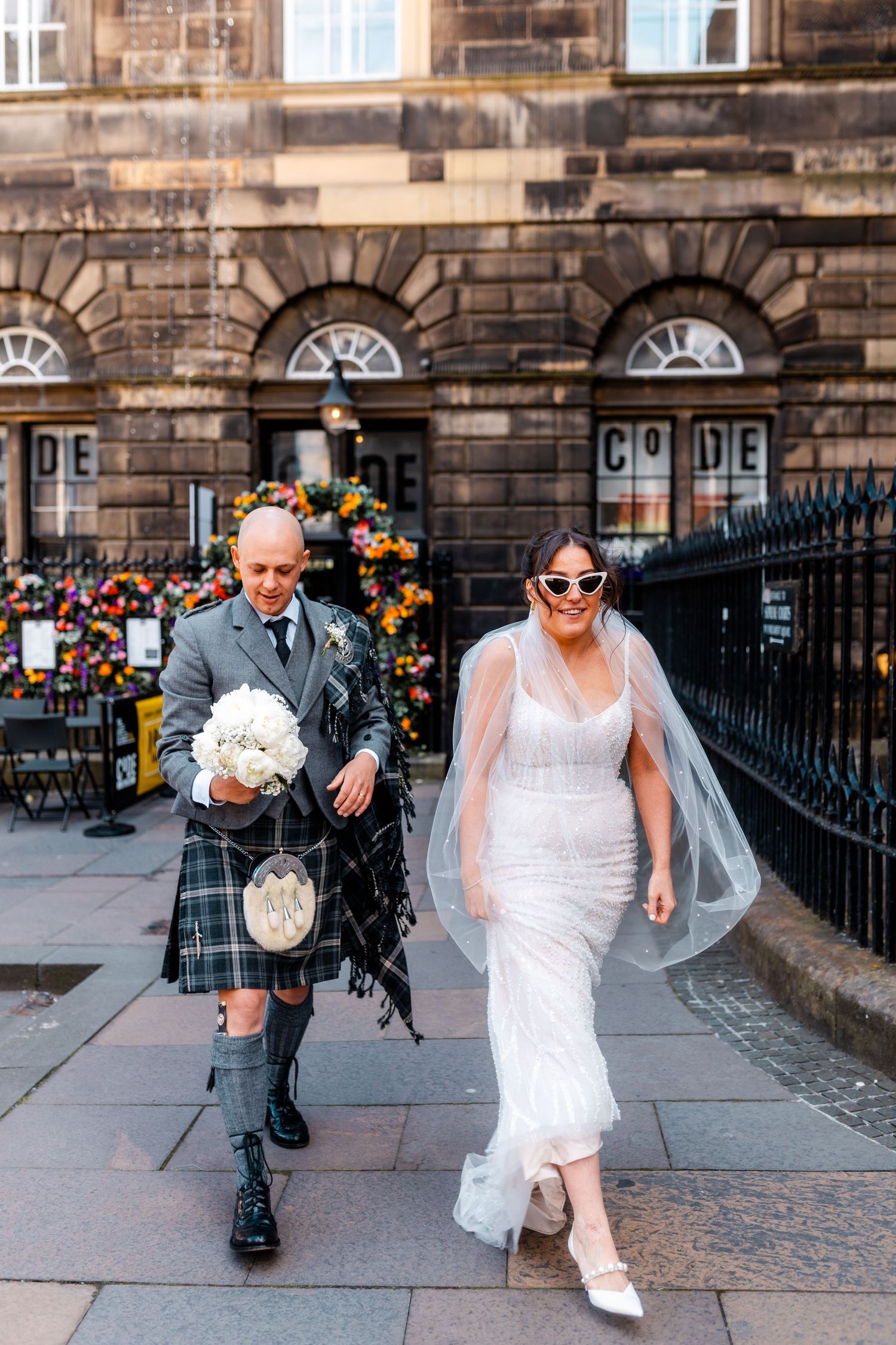 Wedding, bride and groom walking outside City Chambers in Edinburgh, Scotland,