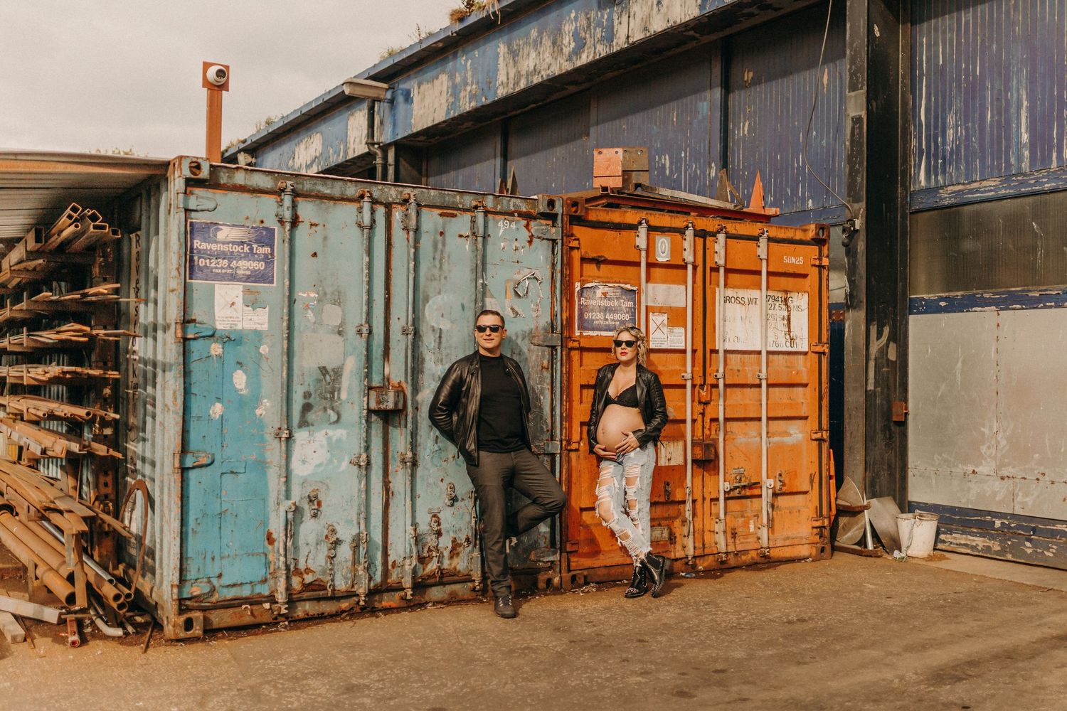 Industrial backdrop with rustic blue metal doors and orange shipping containers.