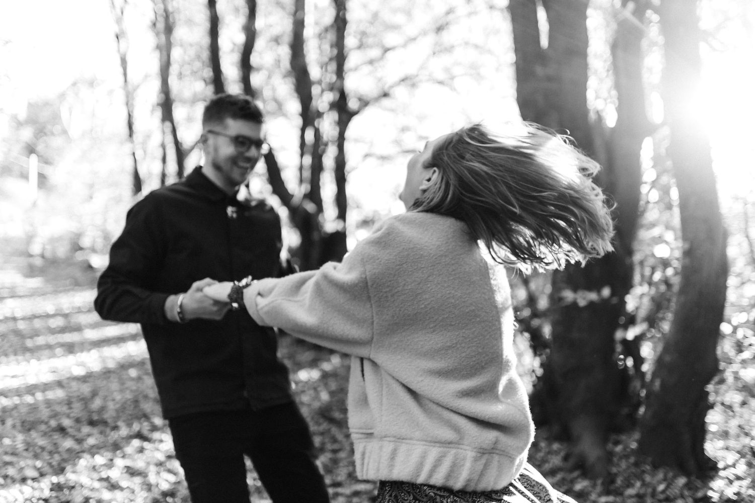 Romantic couple photos taken in a sunlit forest setting with natural lighting.