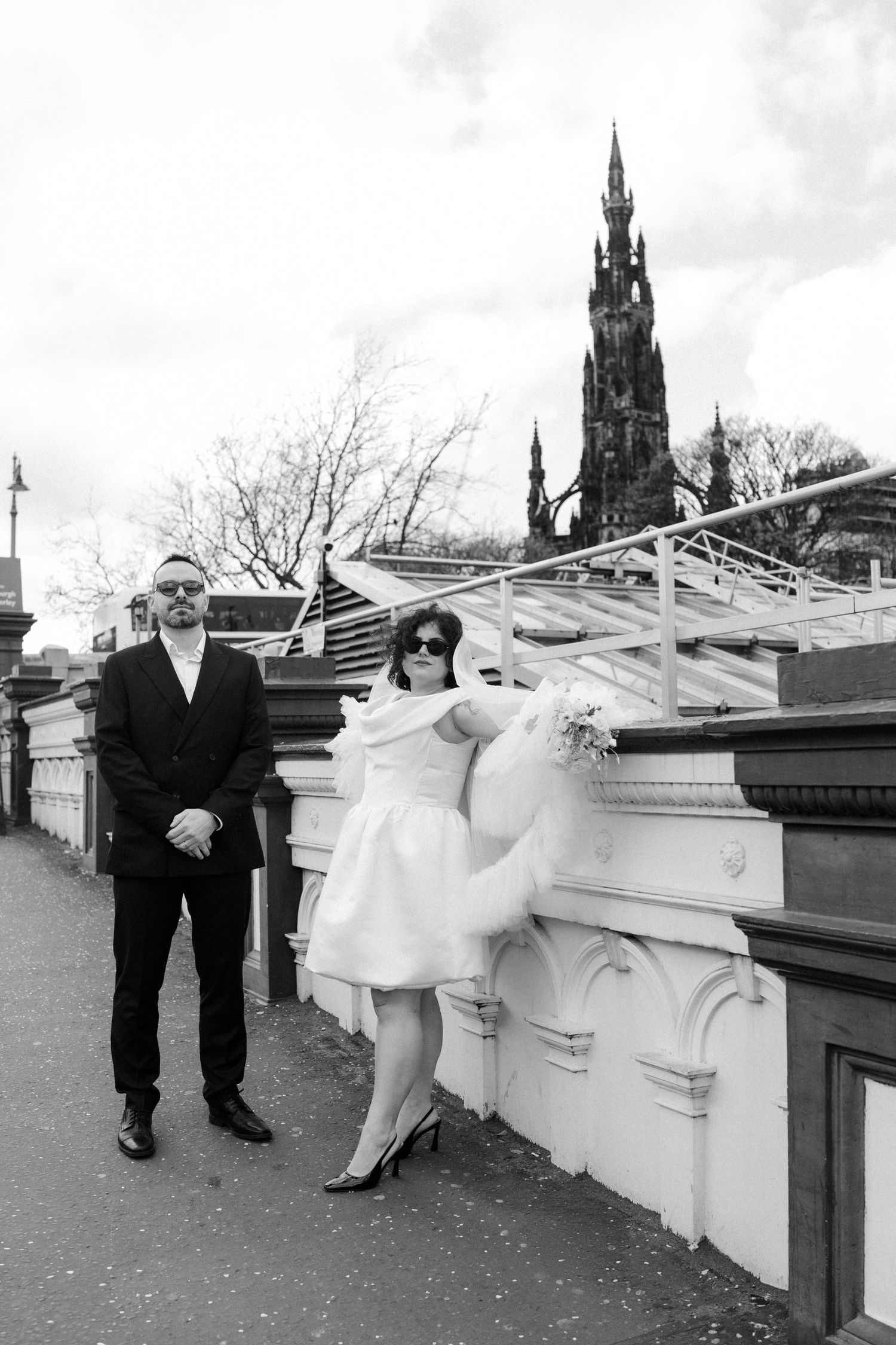 Black and white photo of bride and groom near Scott Monument in Edinburgh, Scotland.