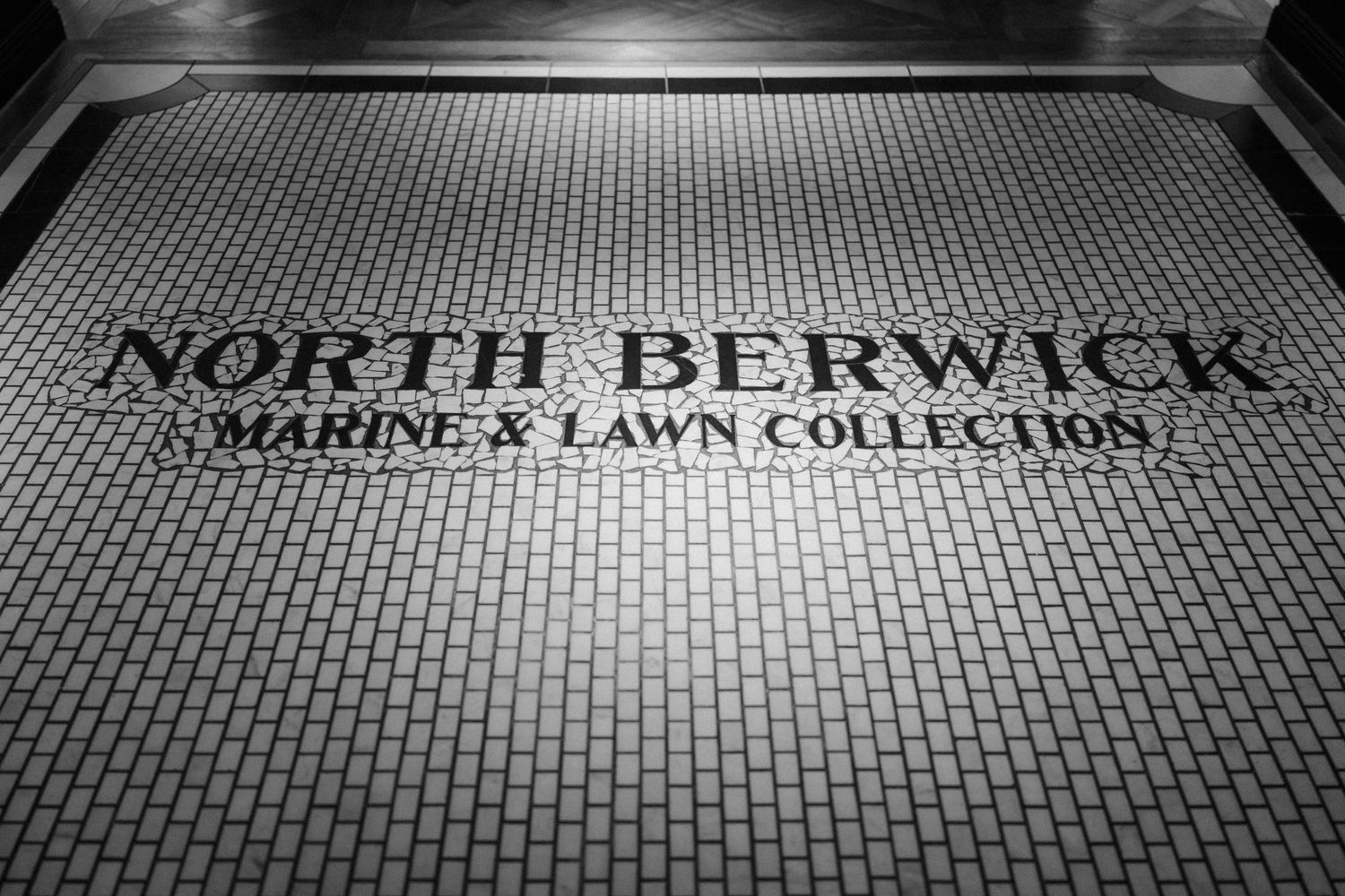 Black and white tiled floor displaying North Berwick Marine X Lawn Collection text in elegant typography.
