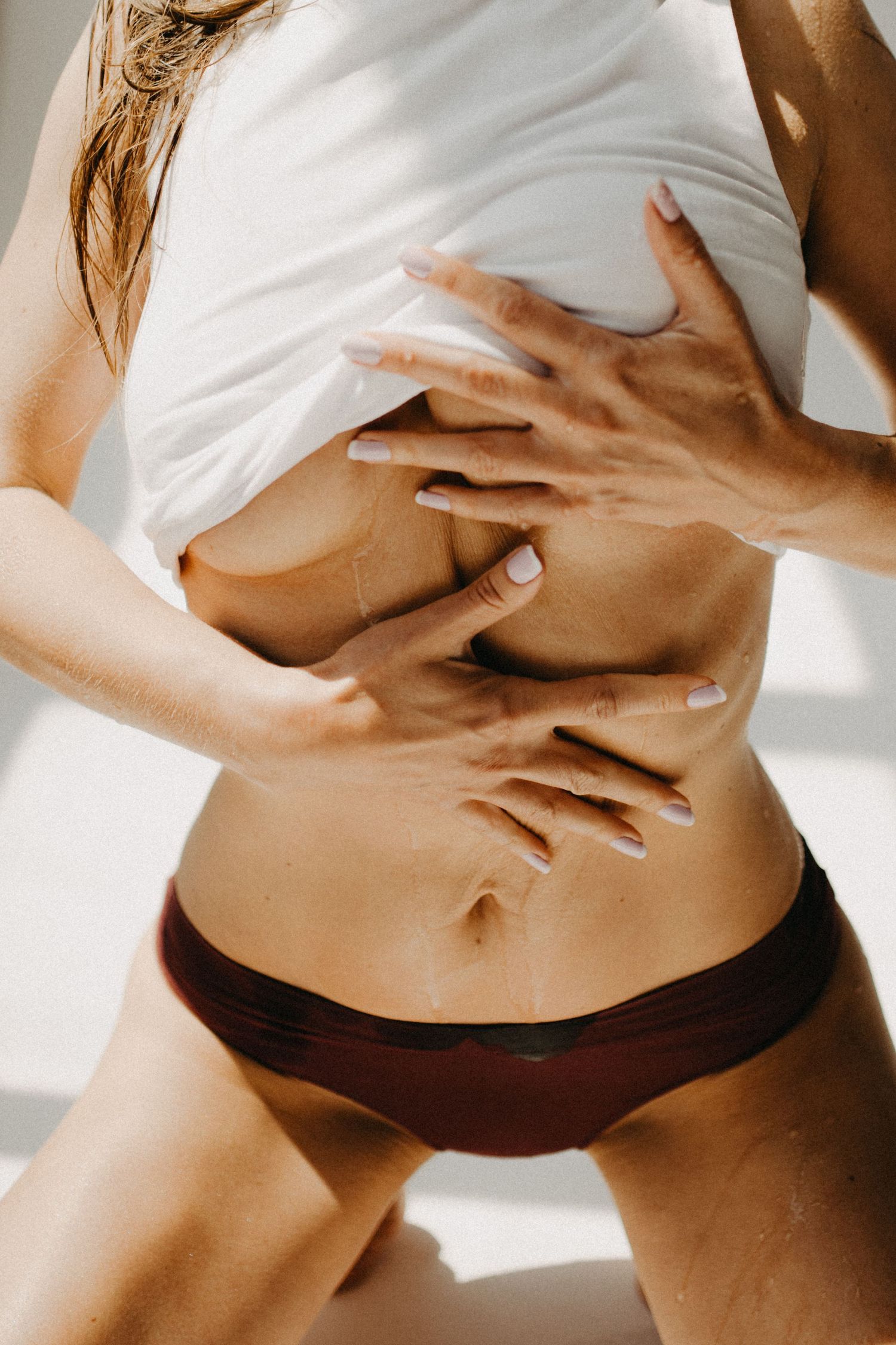 Close-up torso shot in white clothing with hands creating expressive poses.