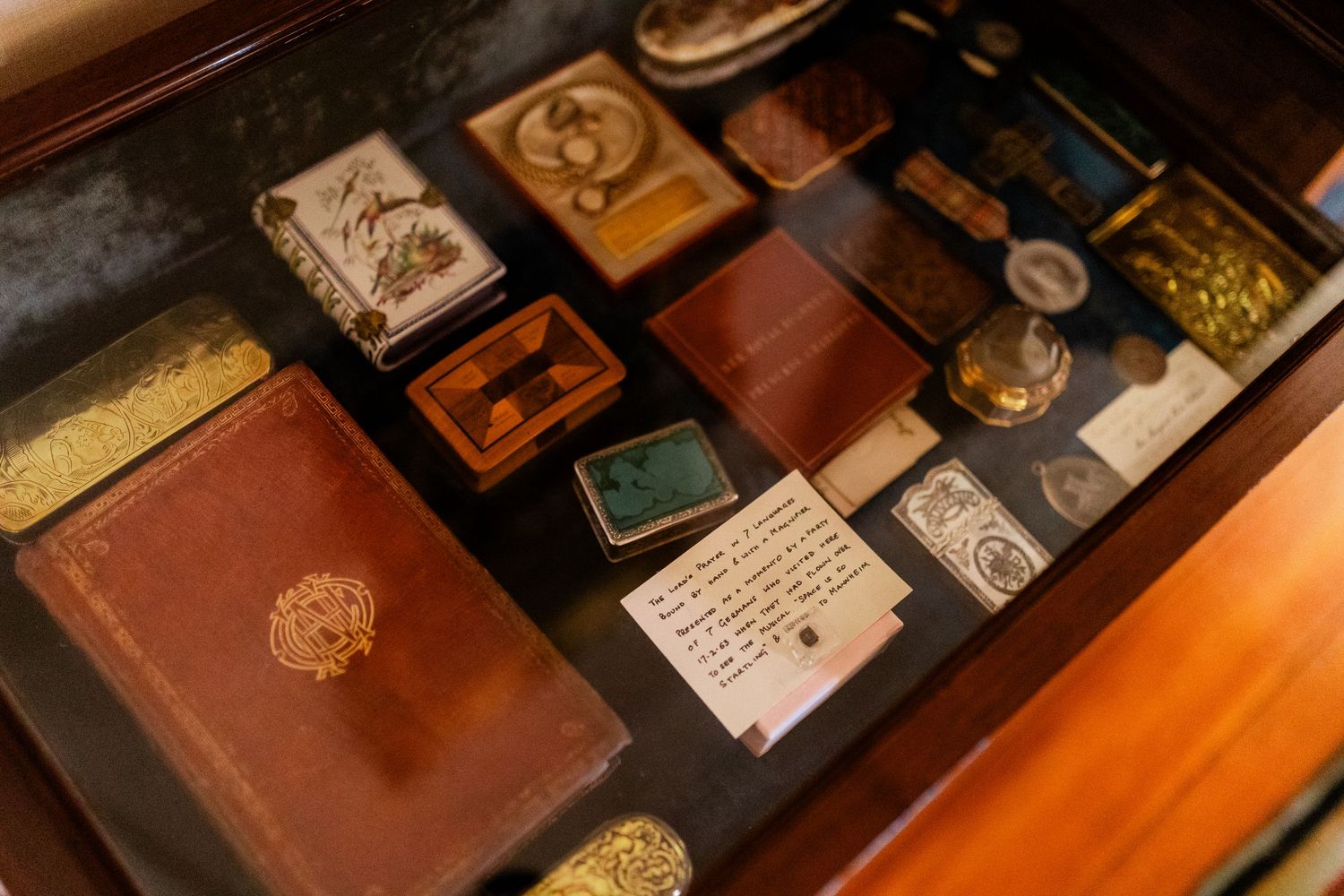 Antique leather-bound books displayed in a row with ornate gold detailing.