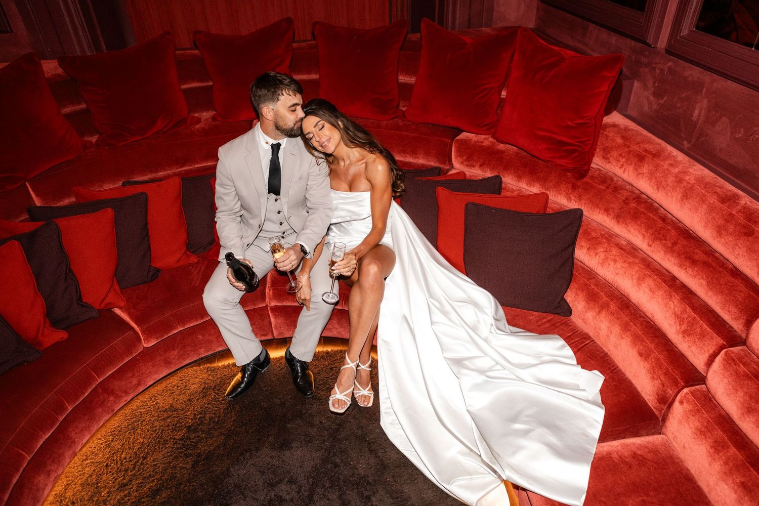 Wedding photos with dramatic red lighting showing a couple on theater-style steps.