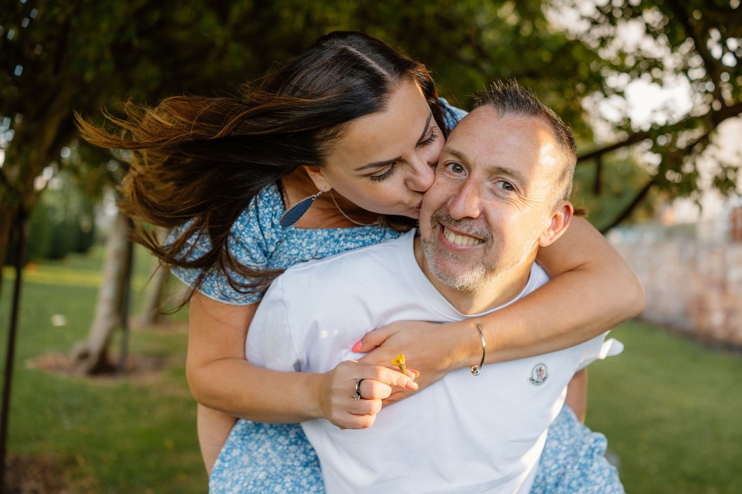 A couple sharing an affectionate moment in a park during golden hour.