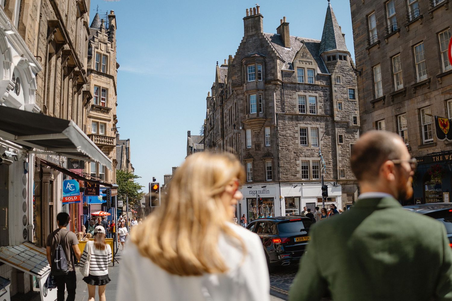 Historic stone buildings and architecture along a street in Edinburgh's Old Town on a sunny day.
