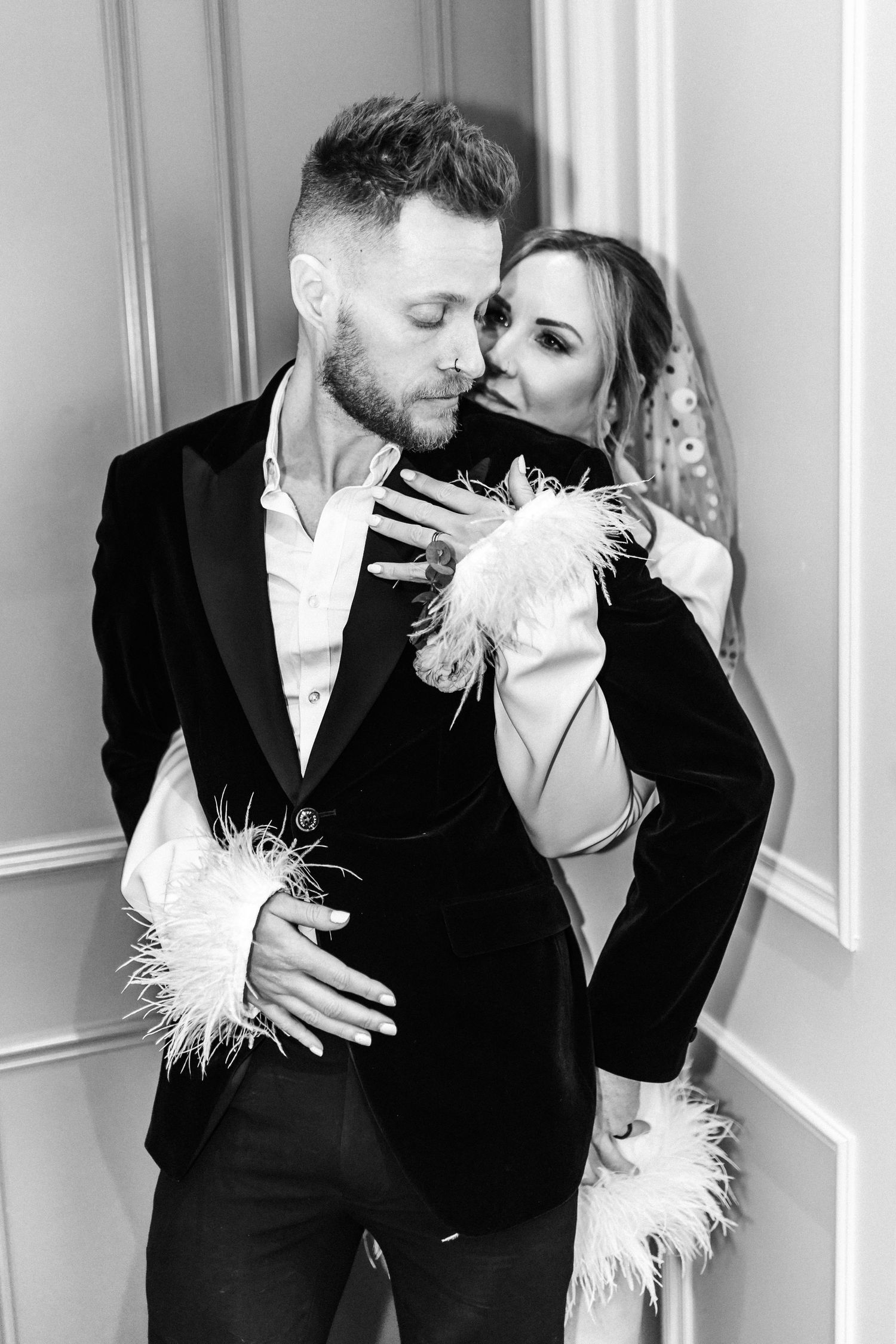 Artistic black and white portraits of a couple in formal wear with feather details.