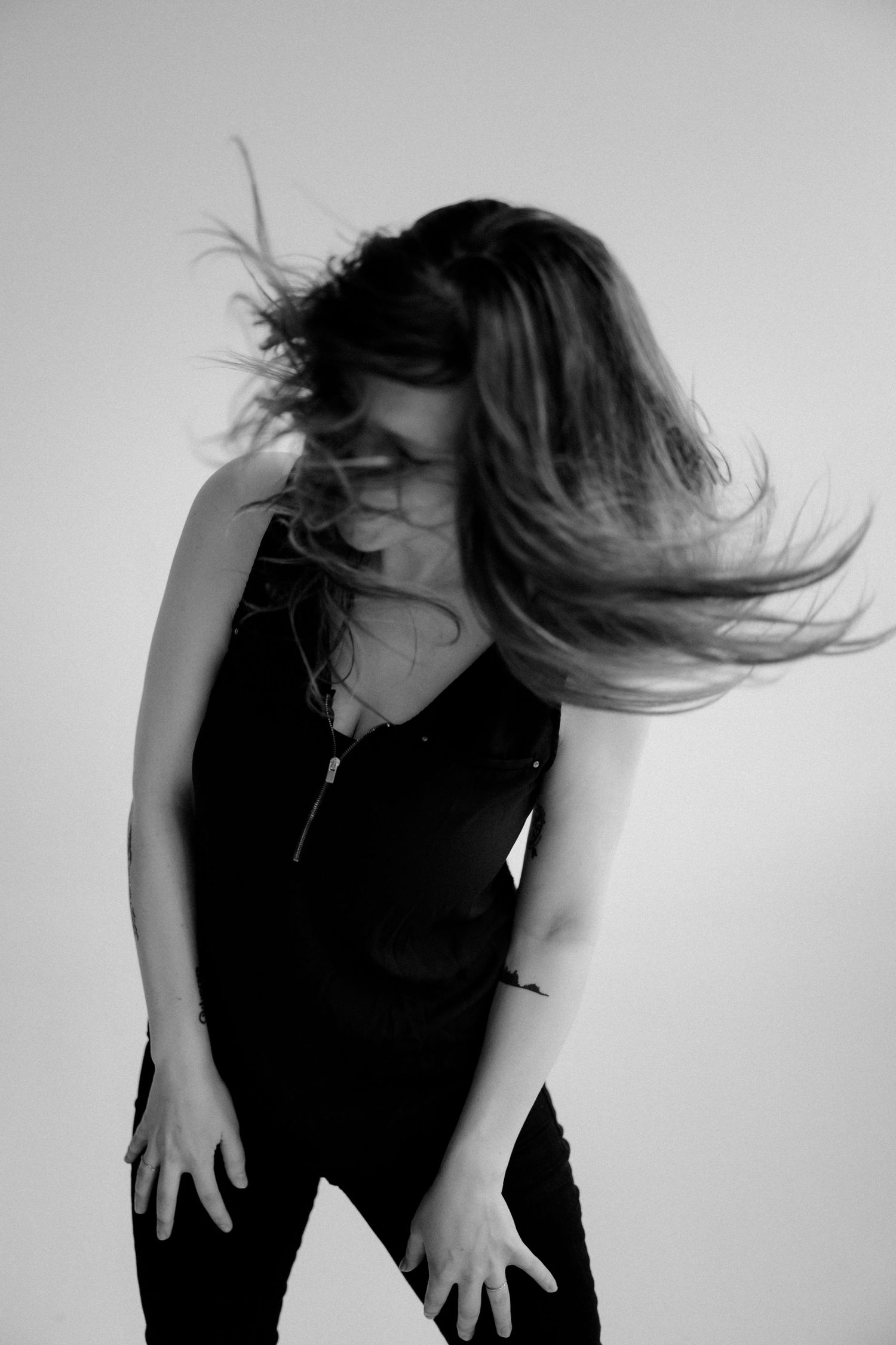Dynamic portrait with hair in motion against white background.