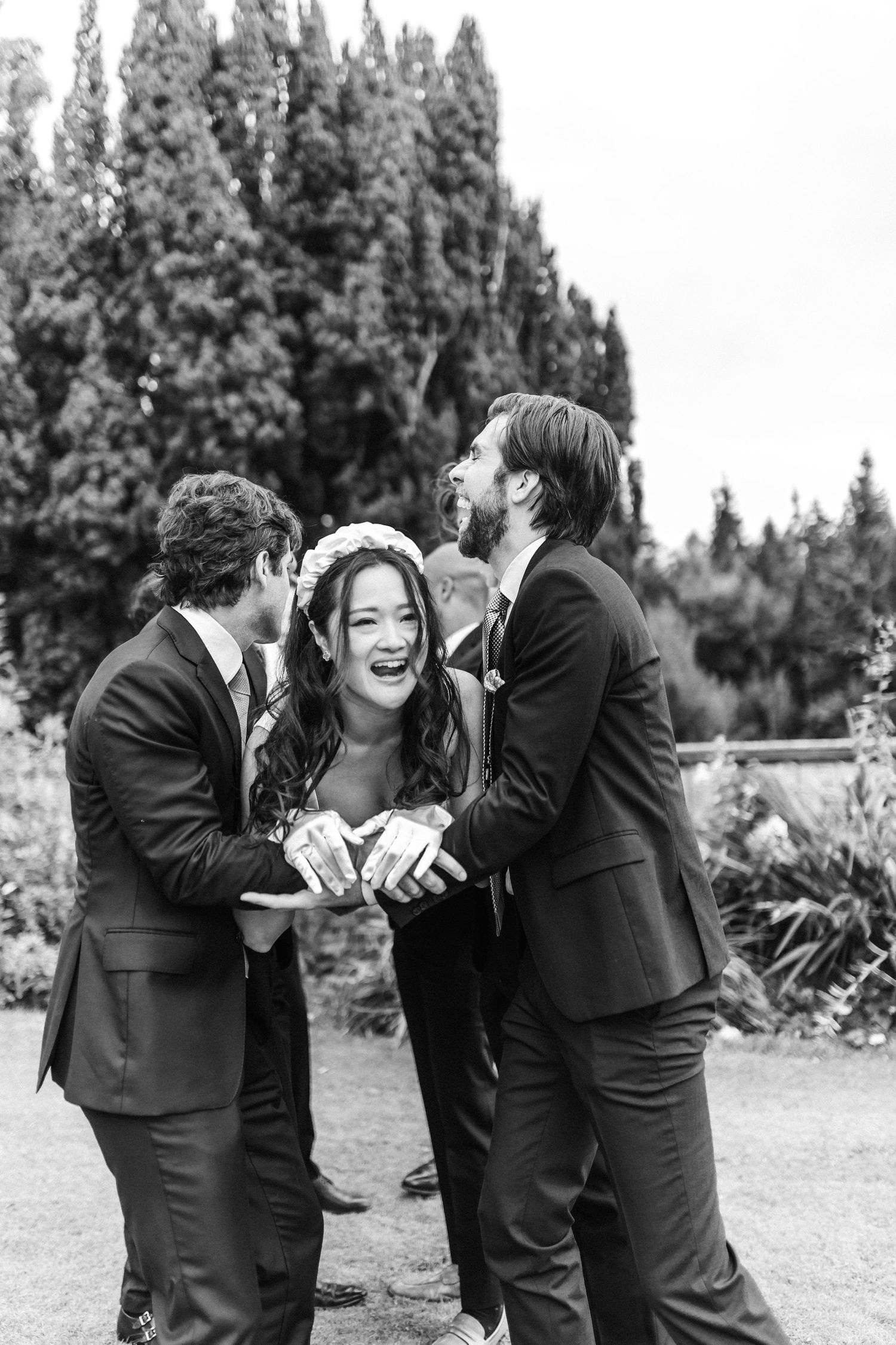 Black and white photos capture joyful candid moments between wedding party members.