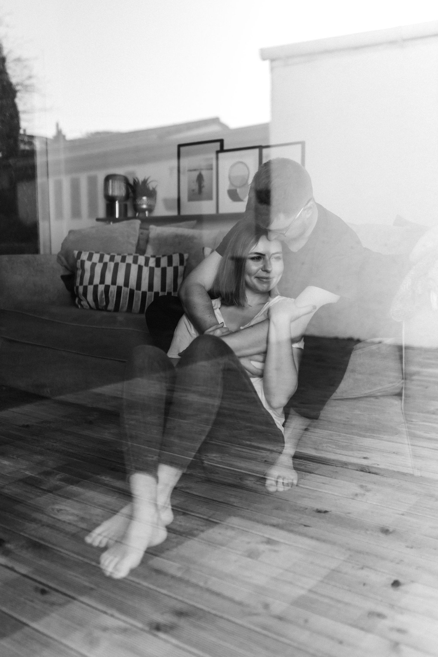 Black and white sequence of playful movements on a hardwood floor.