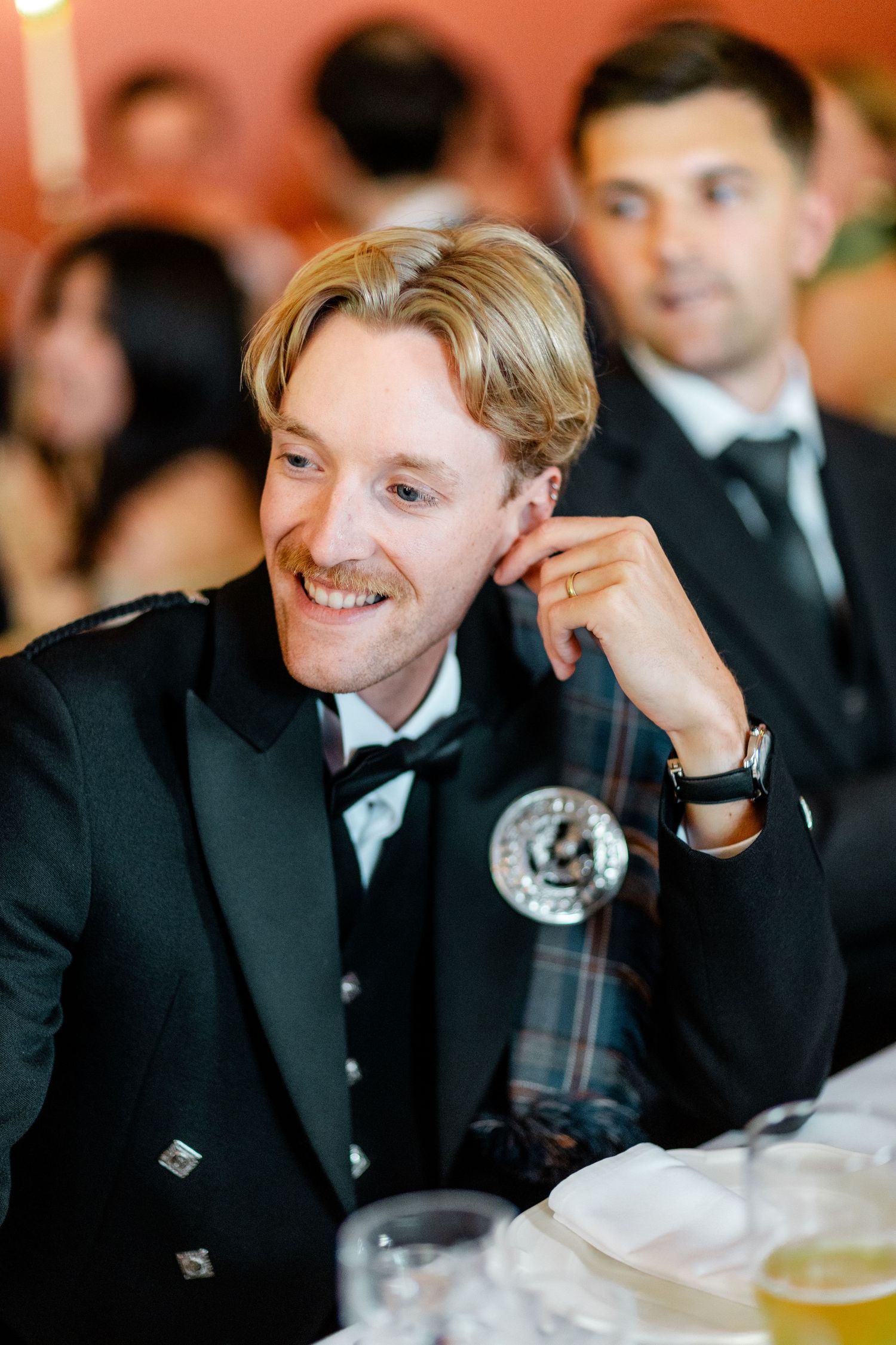 Wedding guest laughing and enjoying themselves at an elegant reception dinner.