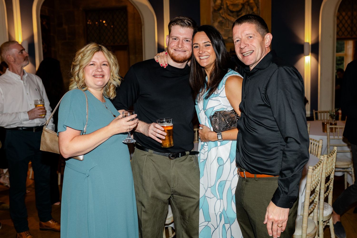 Guests mingle and socialize during an indoor evening reception celebration.