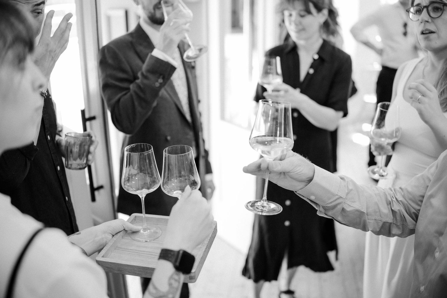 People engaged in lively conversation at a social event in black and white.