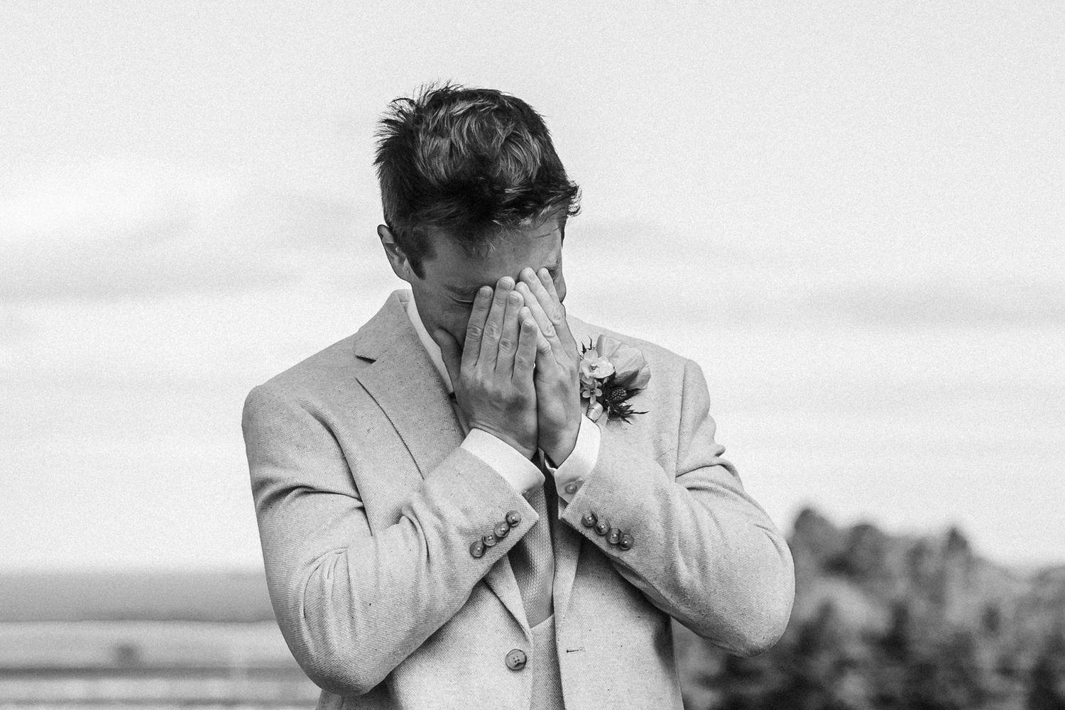 Emotional wedding scene with people embracing outdoors.