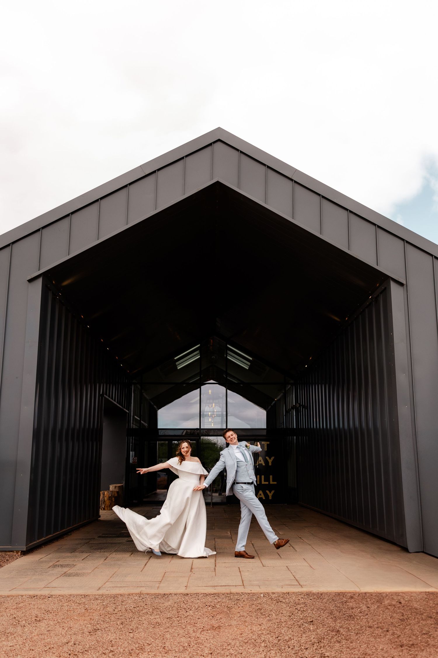 A series of playful wedding photos showing a couple dancing and spinning in a modern architectural space.