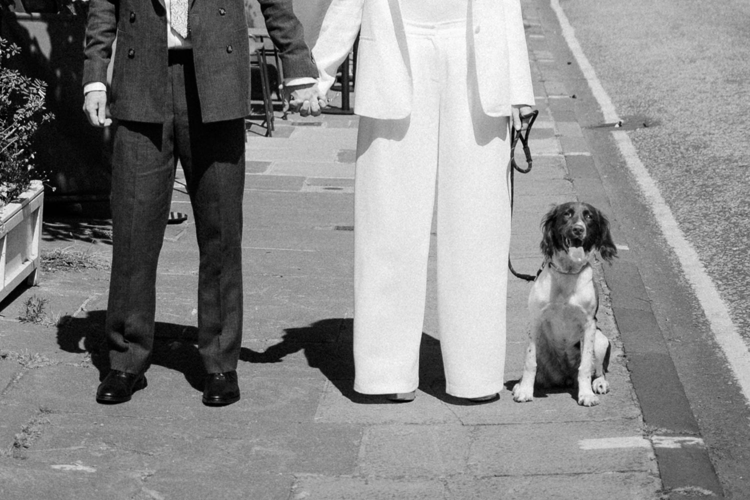 A couple walking together outdoors in formal attire.